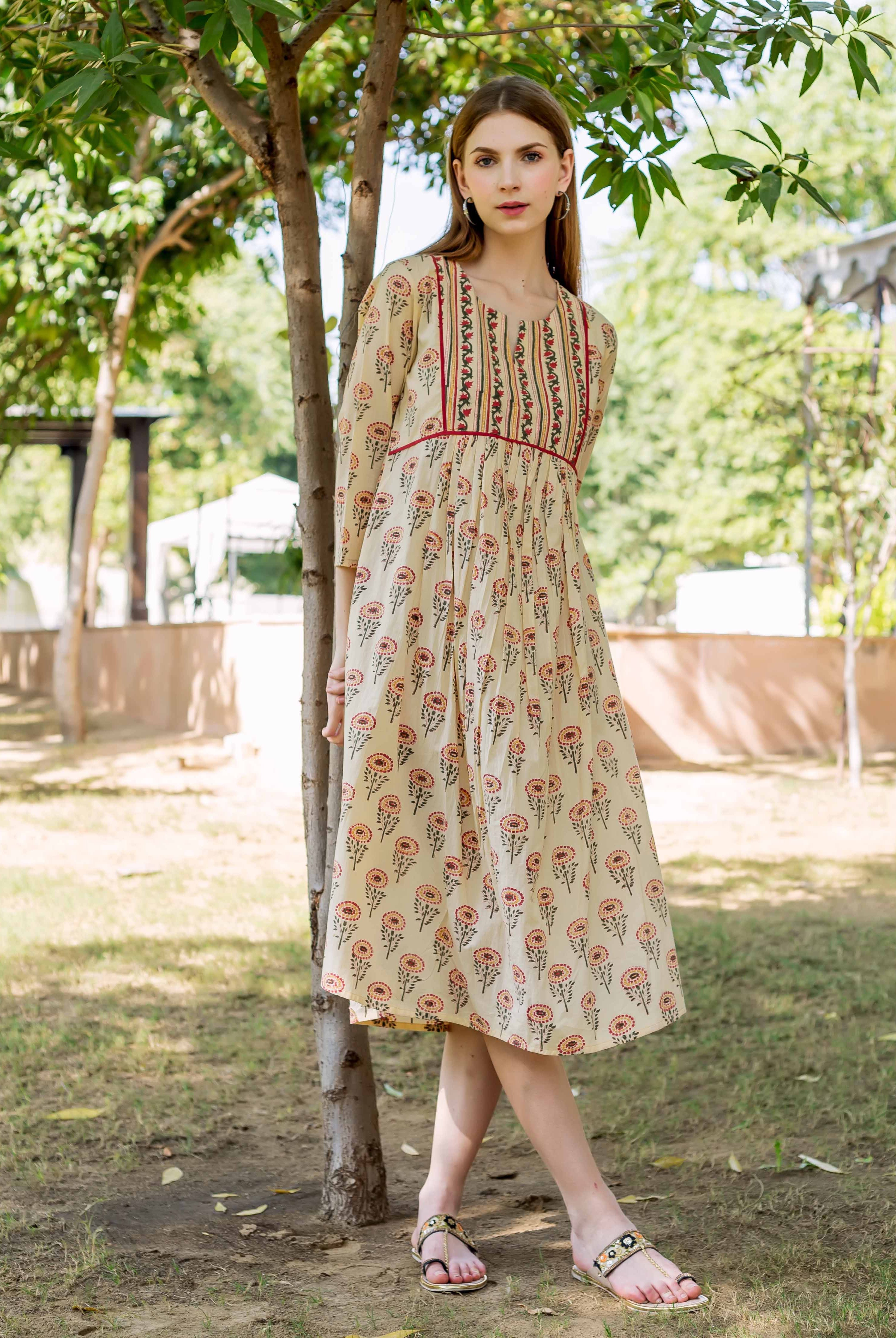 Woman in a cream multicolour hand block printed floral midi dress outdoors.