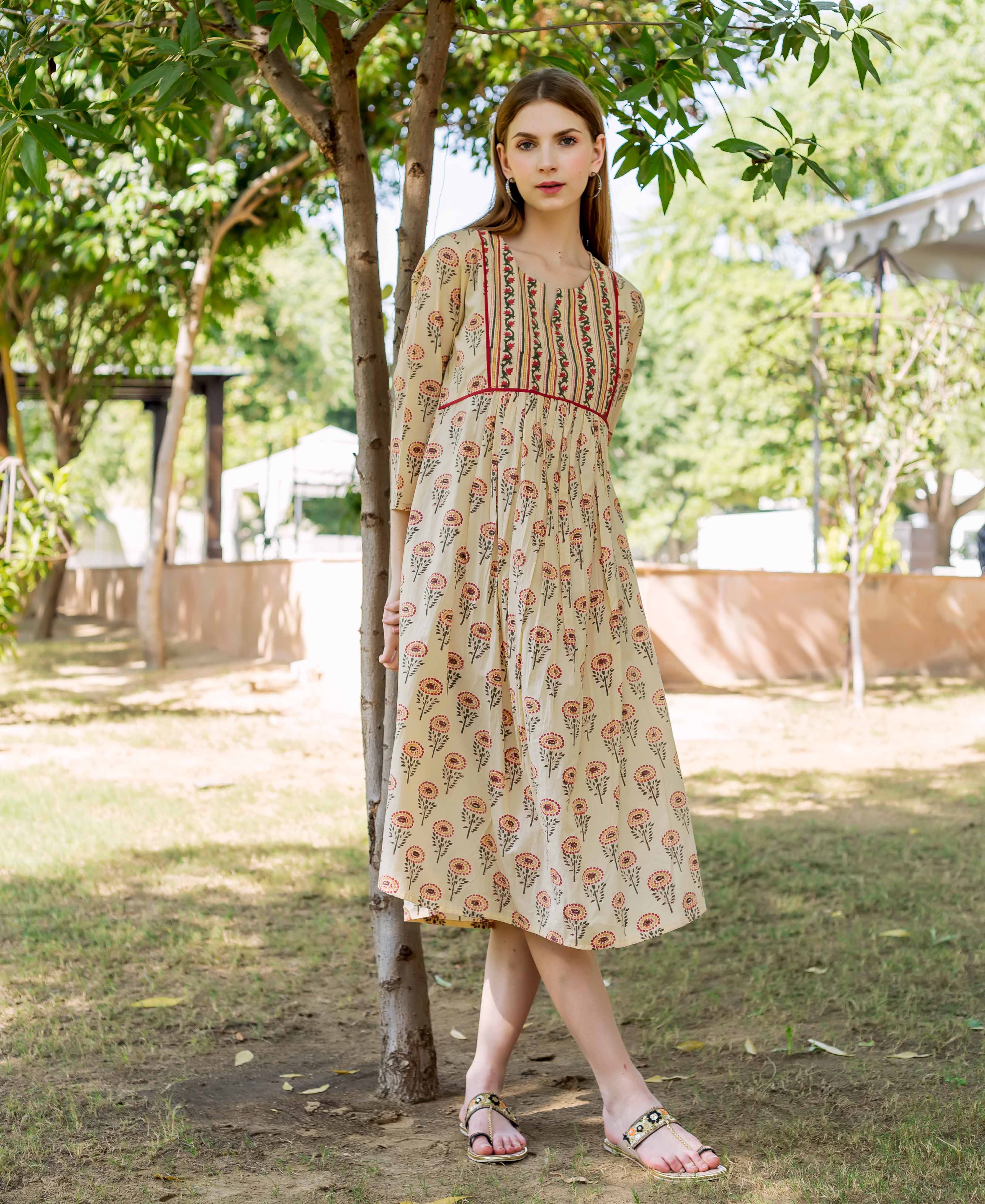 Woman in a cream multicolour hand block printed floral midi dress outdoors.