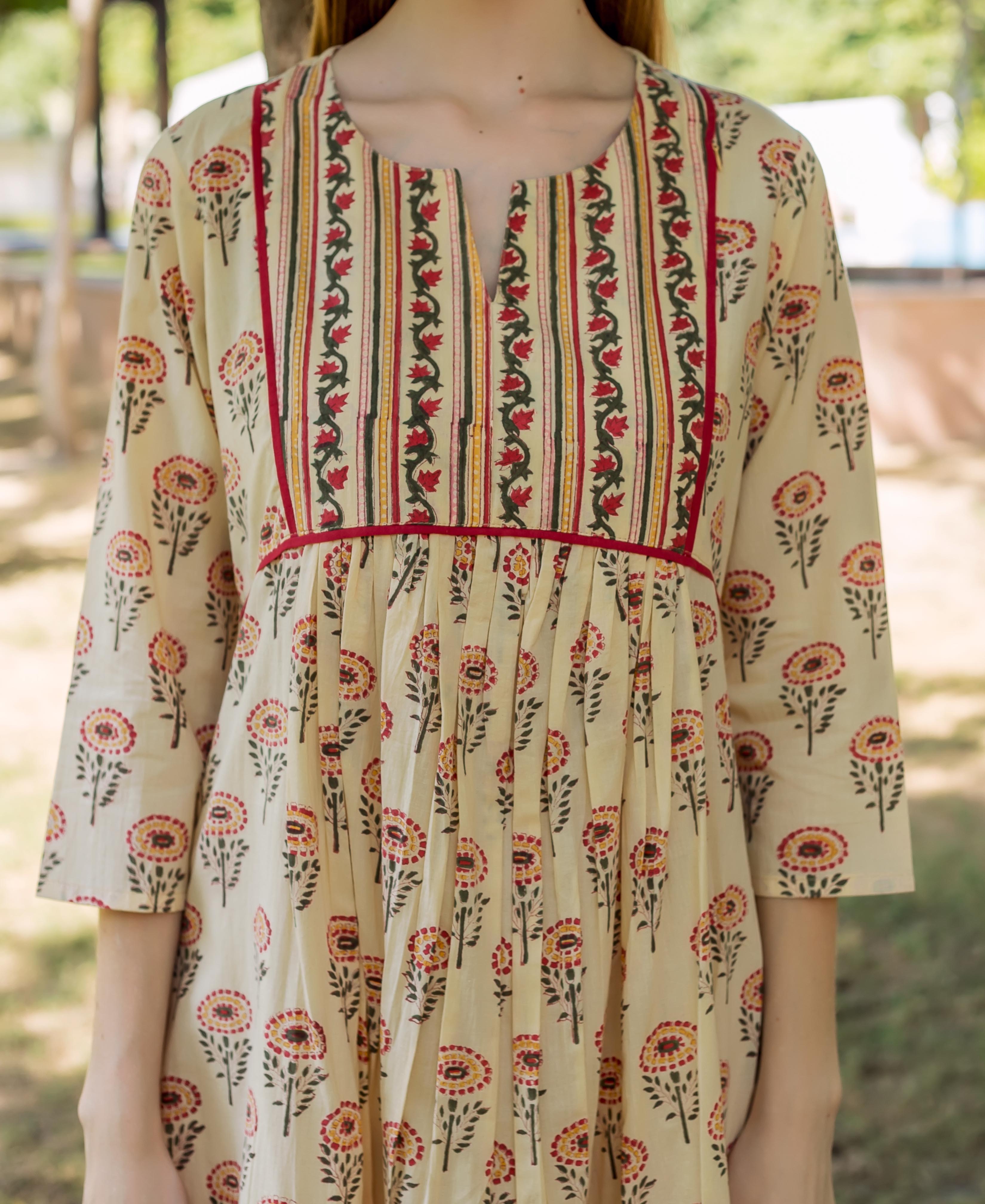 Light yellow hand-block printed dress with a patterned bodice, pleated skirt, and multi-color floral print.