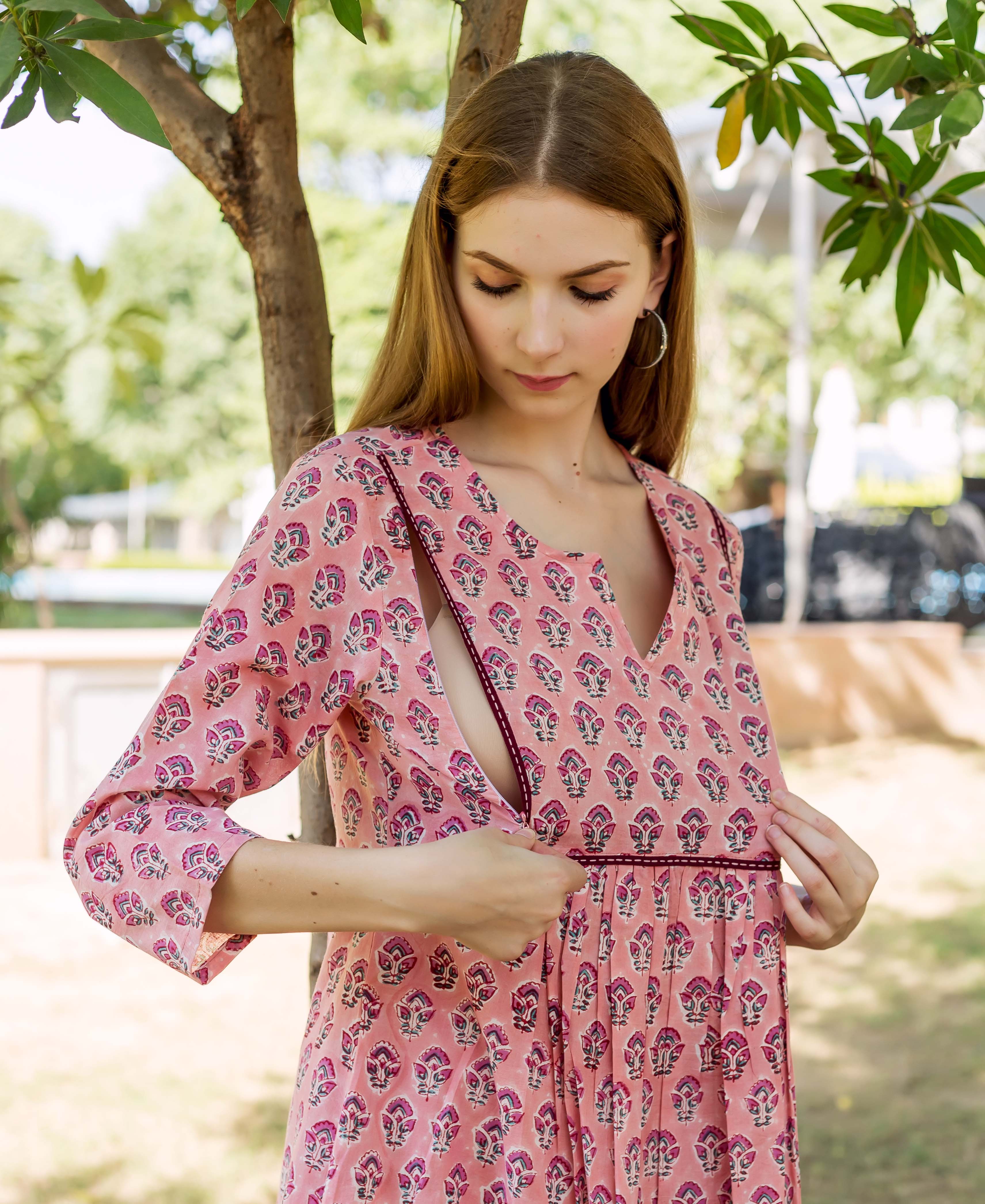 A woman wearing a peach hand-block-printed dress with a floral pattern.