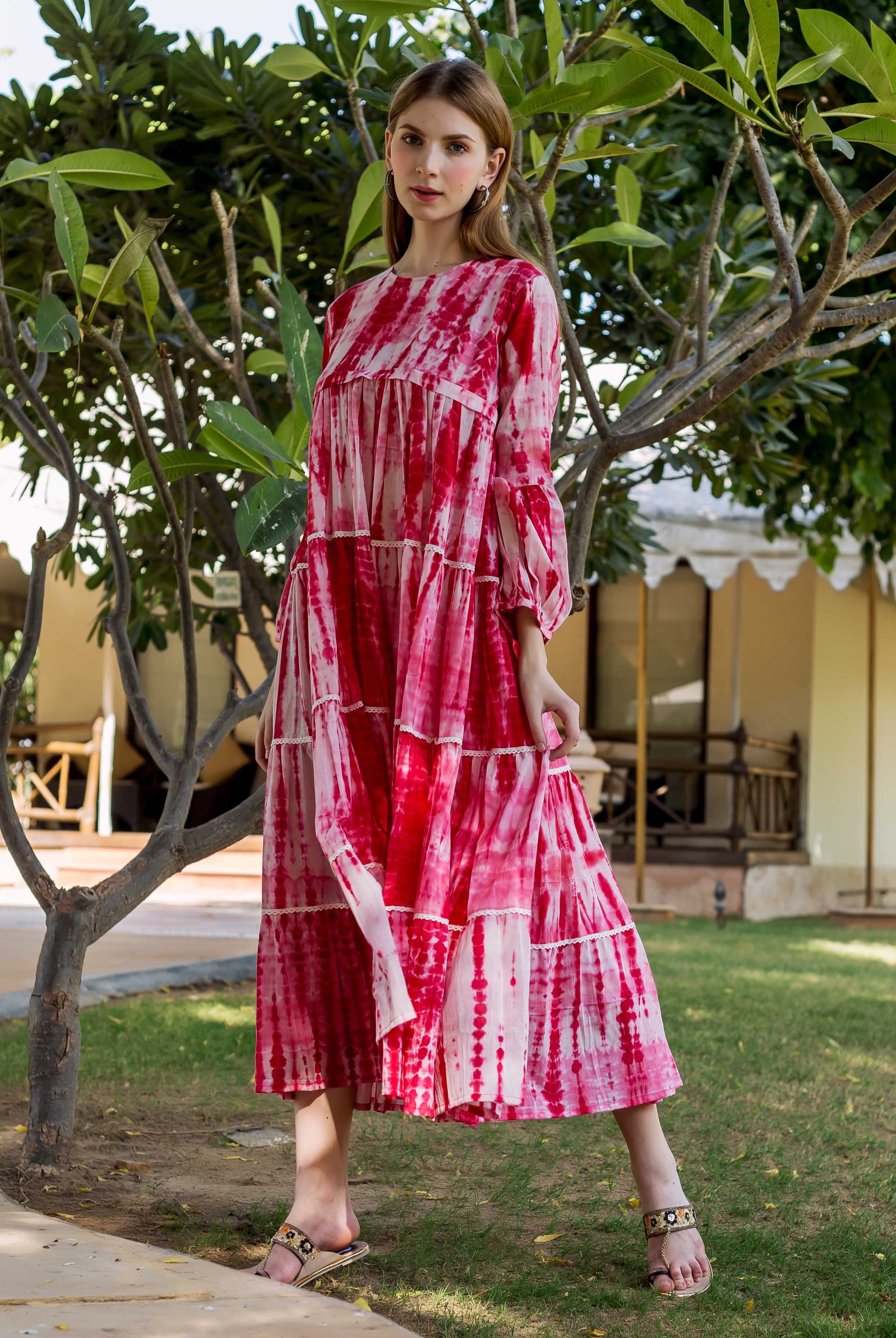 Model wearing a red and white shibori tie-dye tiered maxi dress outdoors.