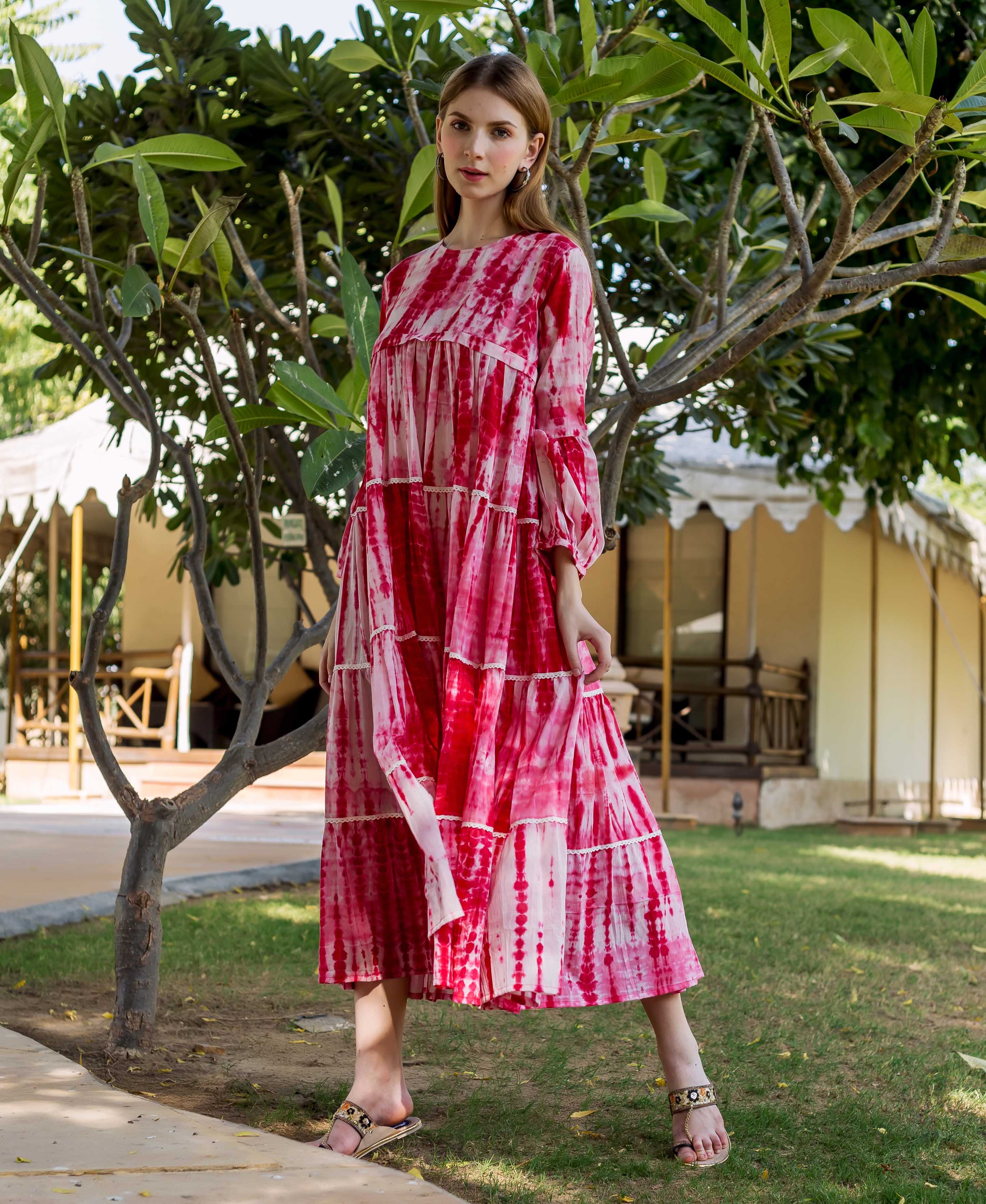 Model wearing a red and white shibori tie-dye tiered maxi dress outdoors.