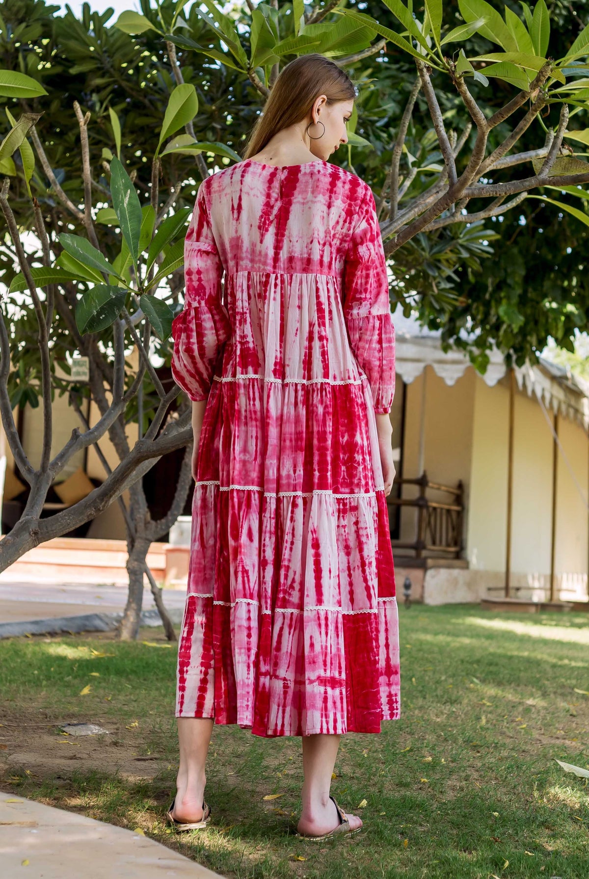 Woman from back in red and white tie-dye tiered midi dress with balloon sleeves.