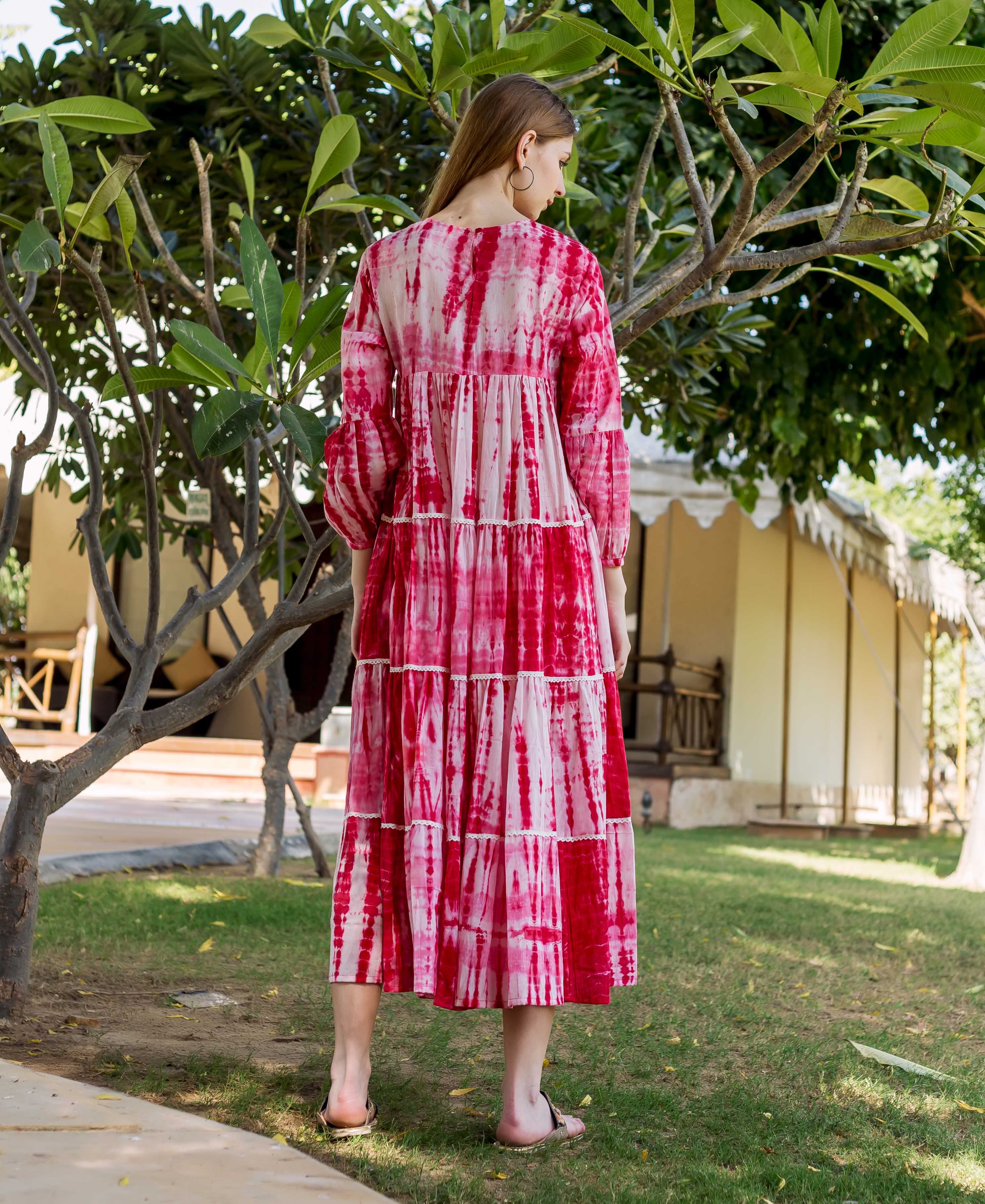 Woman from back in red and white tie-dye tiered midi dress with balloon sleeves.
