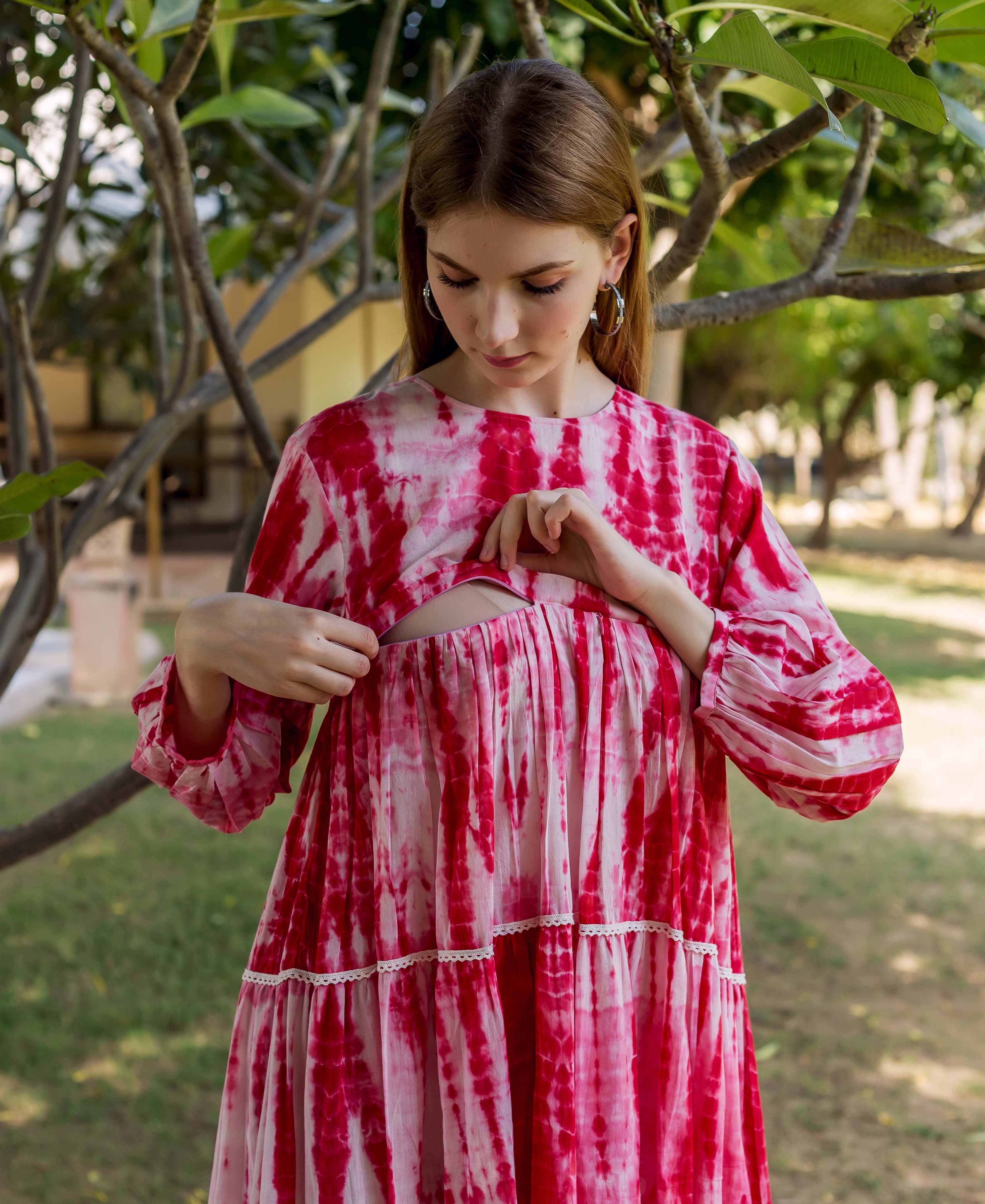 Model showcasing red and white tie-dye tiered maternal dress with nursing access.