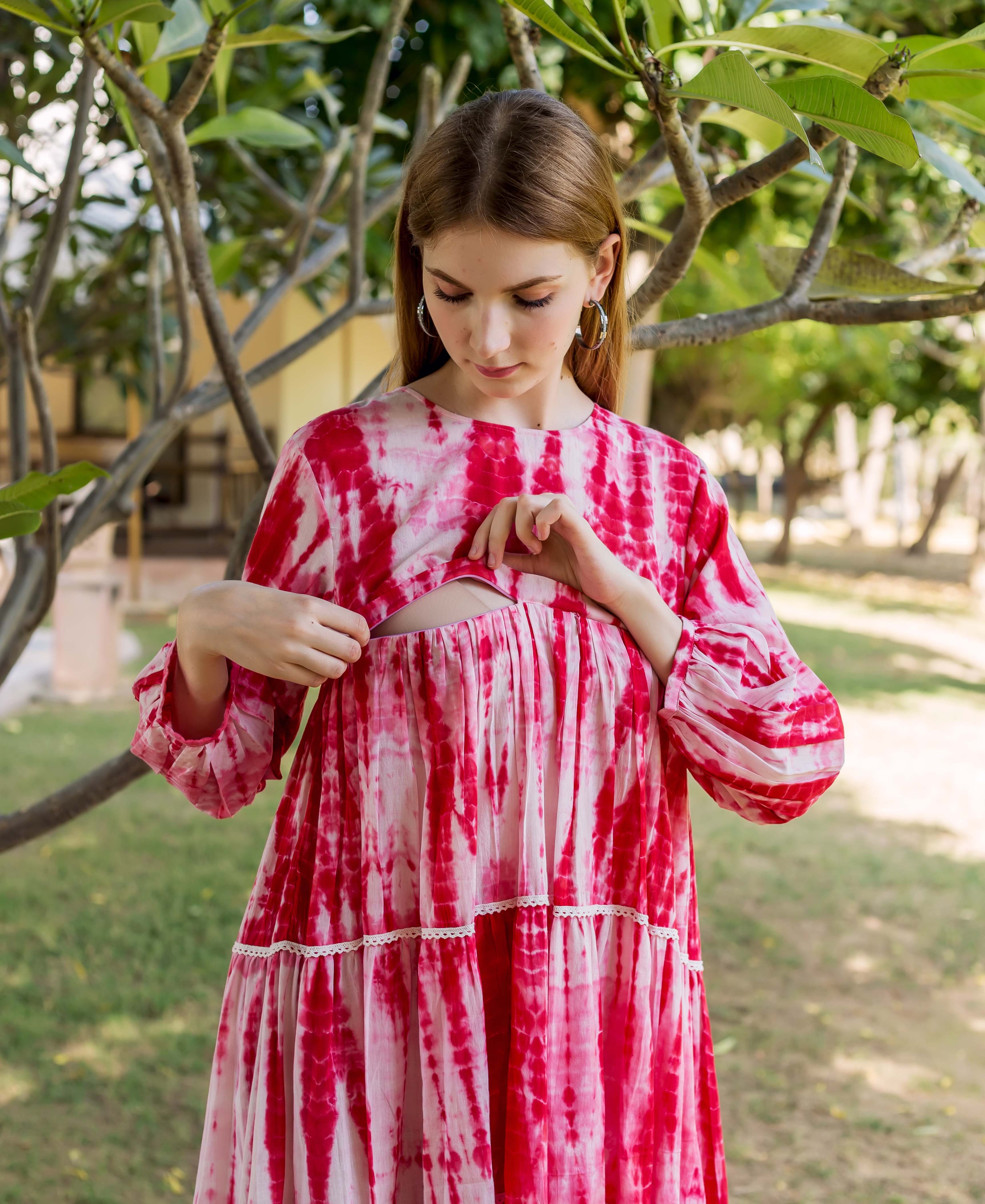 Model showcasing nursing access on a red tie-dye tiered maternal and nursing dress.