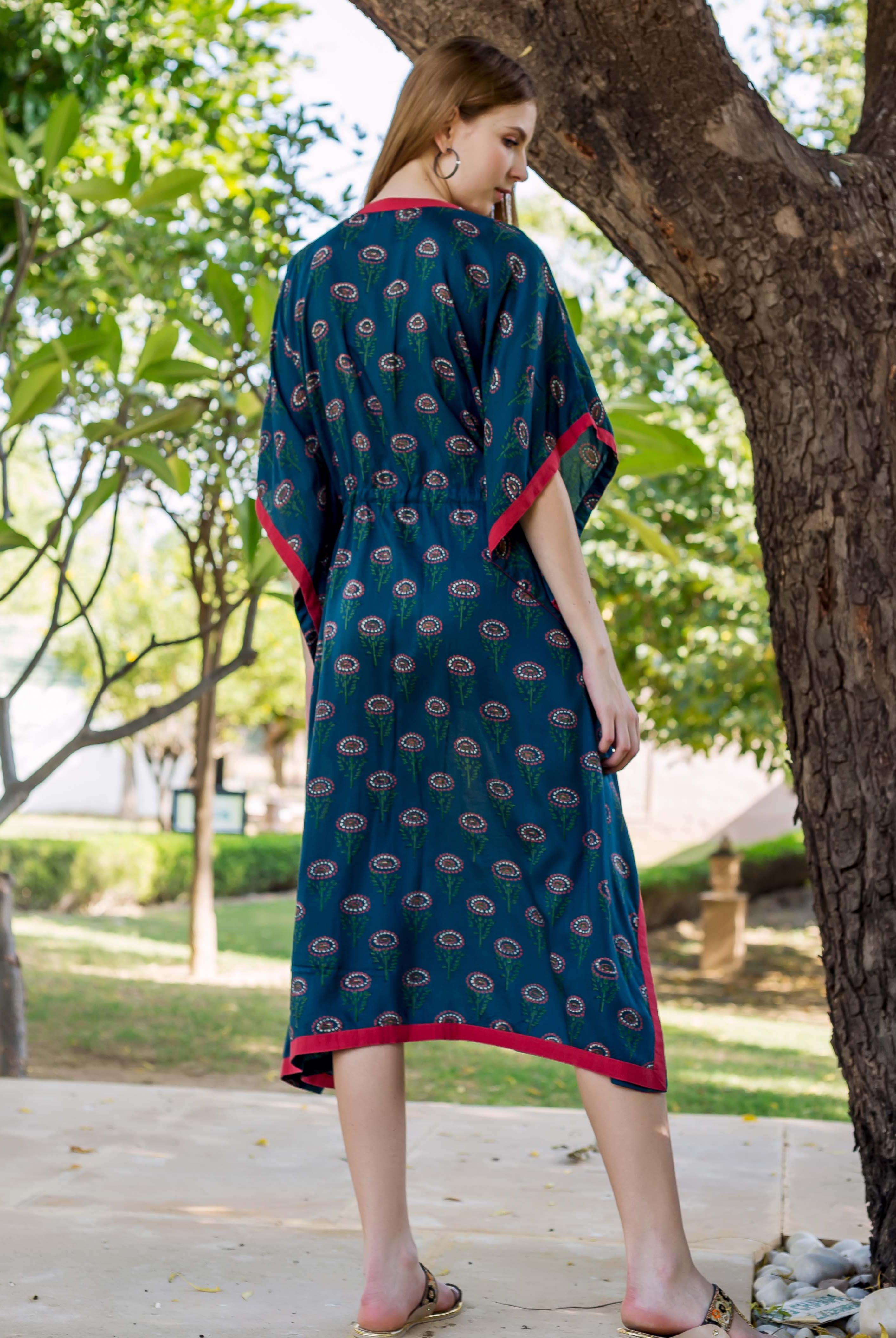 Back view of model in peacock green hand-block-printed kaftan with red trim.
