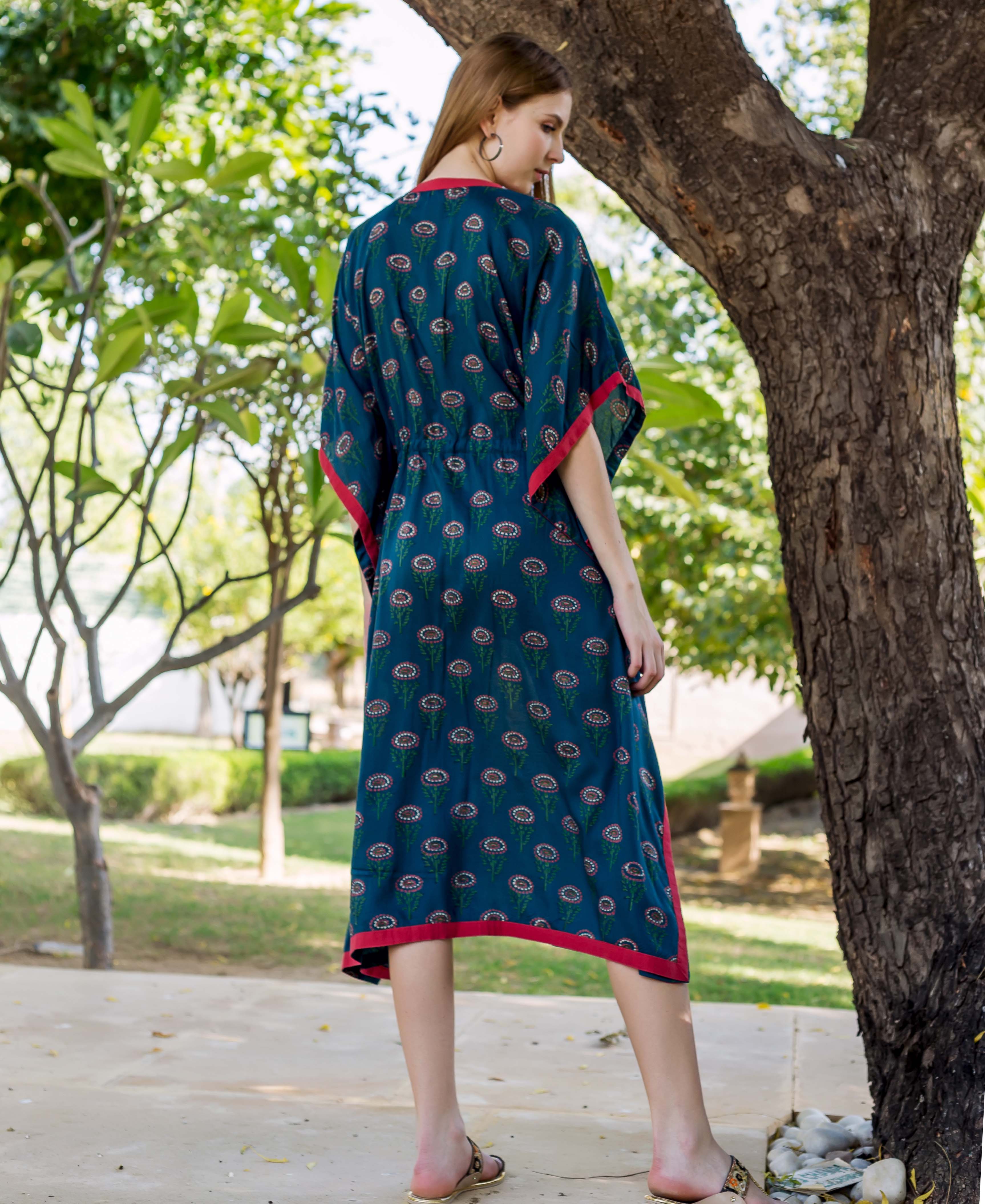 Back view of model in peacock green hand-block-printed kaftan with red trim.