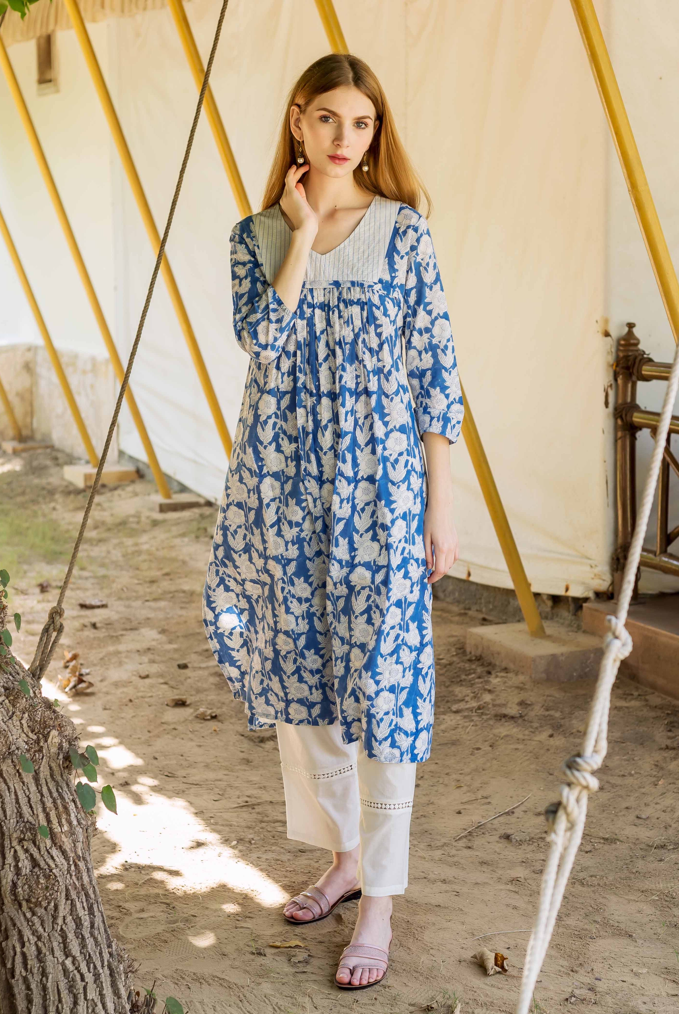 Front view of a model wearing a blue and white hand block printed floral kurta with white pants.