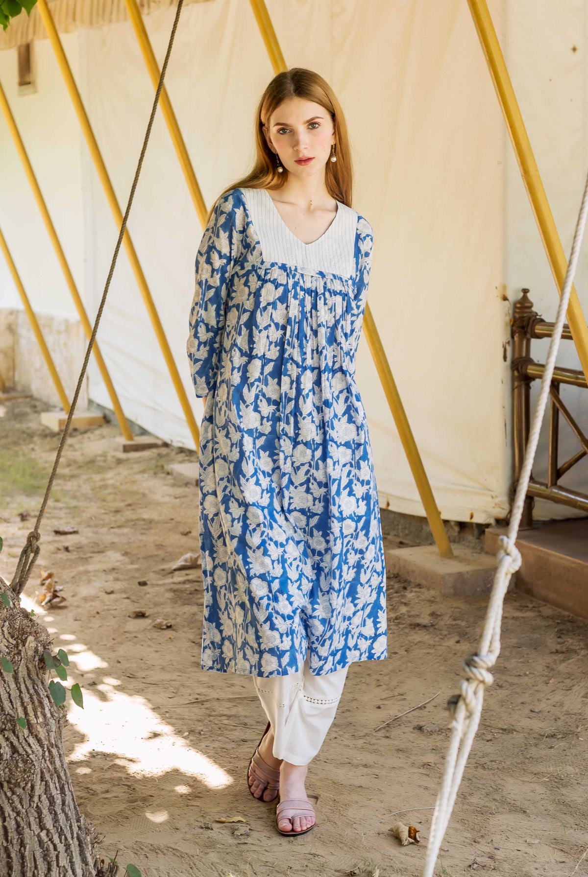 Front view of model in blue and white floral hand block printed kurta with white pants.