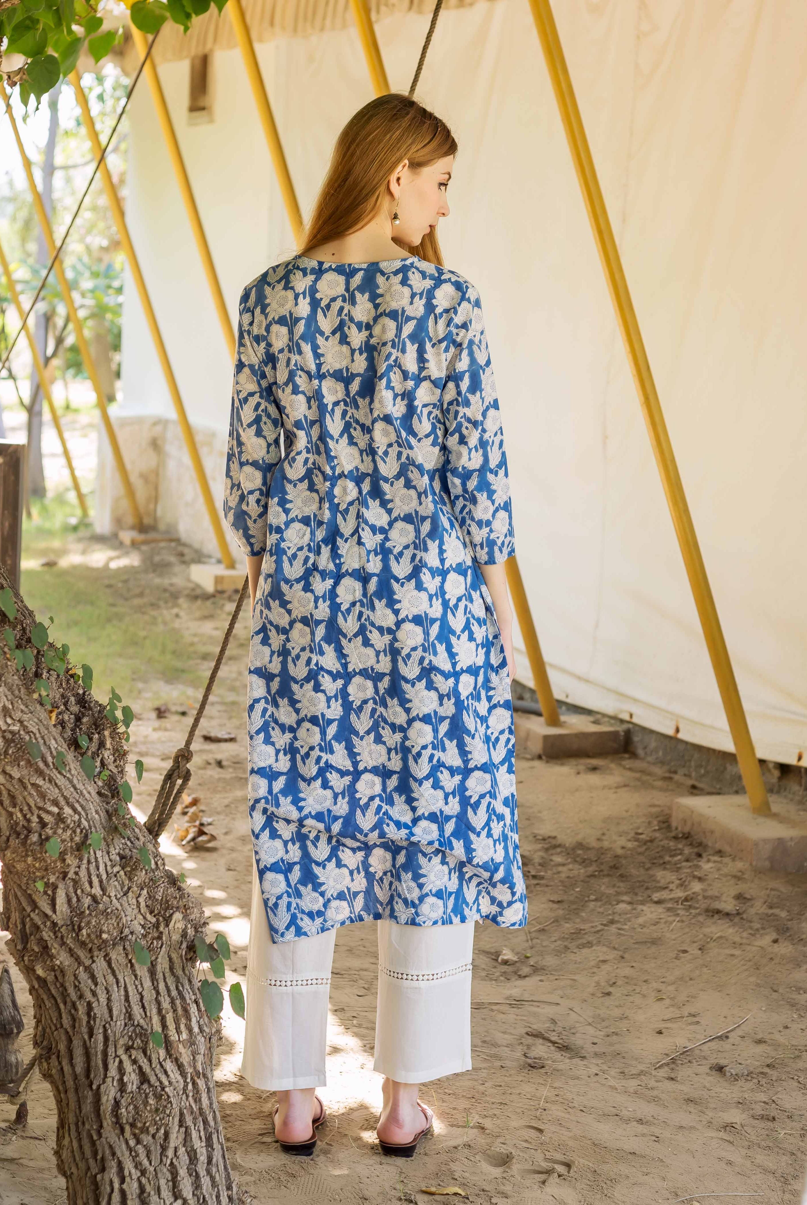 Back view of model in blue and white floral hand block printed kurta and white pants.