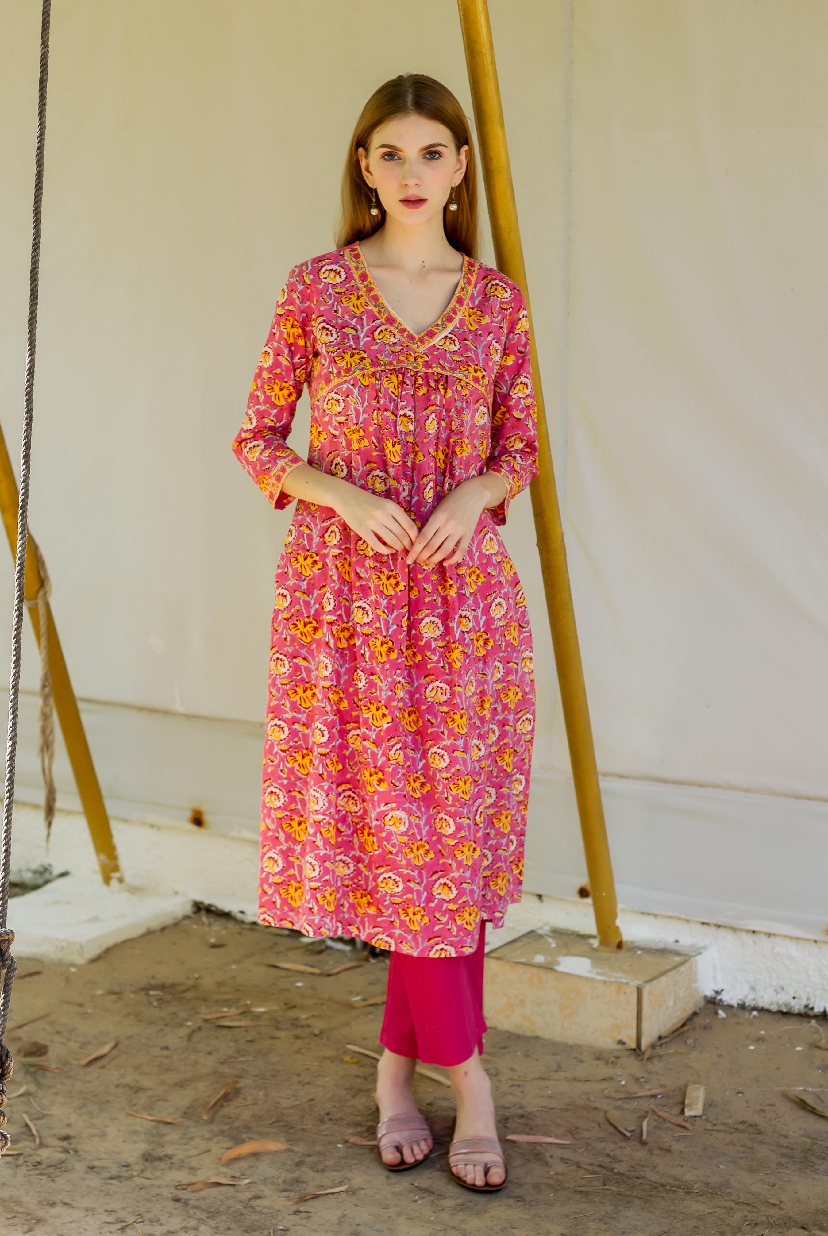 Model in pink hand block printed maternal and nursing kurta with yellow floral pattern.