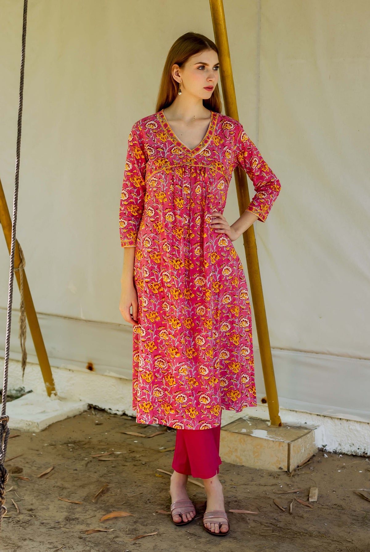 A model wearing a pink hand-block-printed kurta with yellow floral patterns.