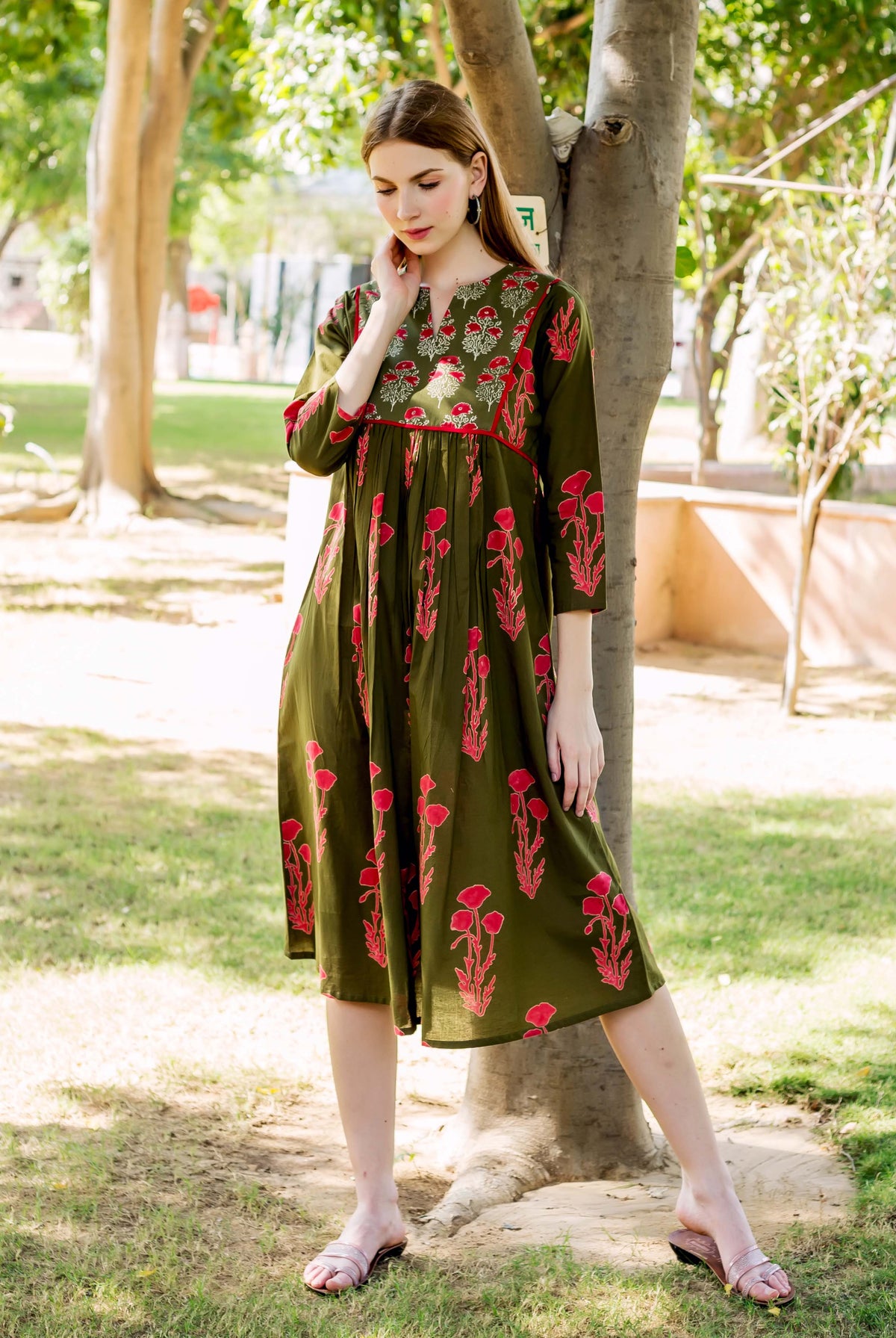 Olive green maternal dress with red hand block printed flowers on model.