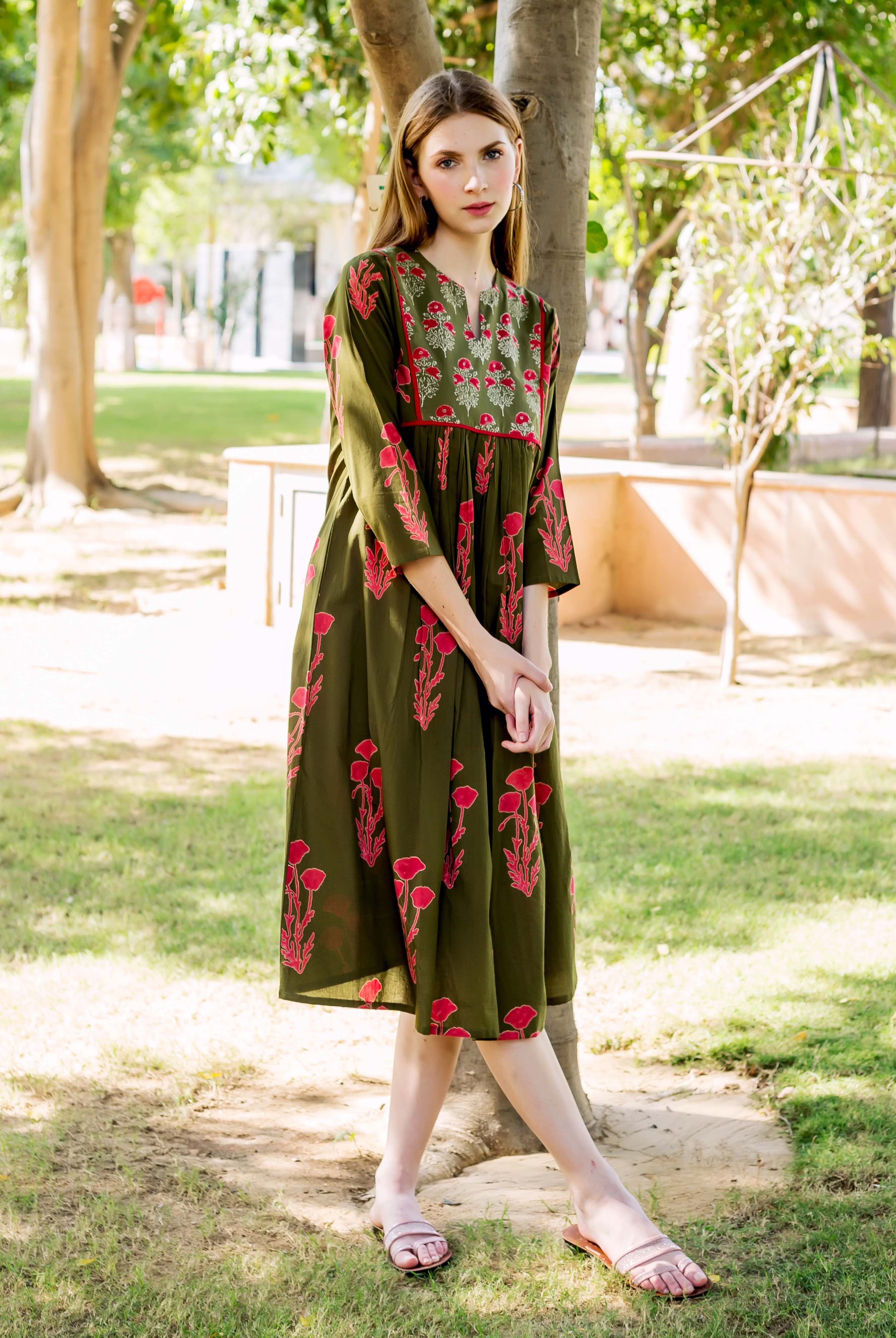 Olive green hand block printed dress with red floral patterns on a standing model.