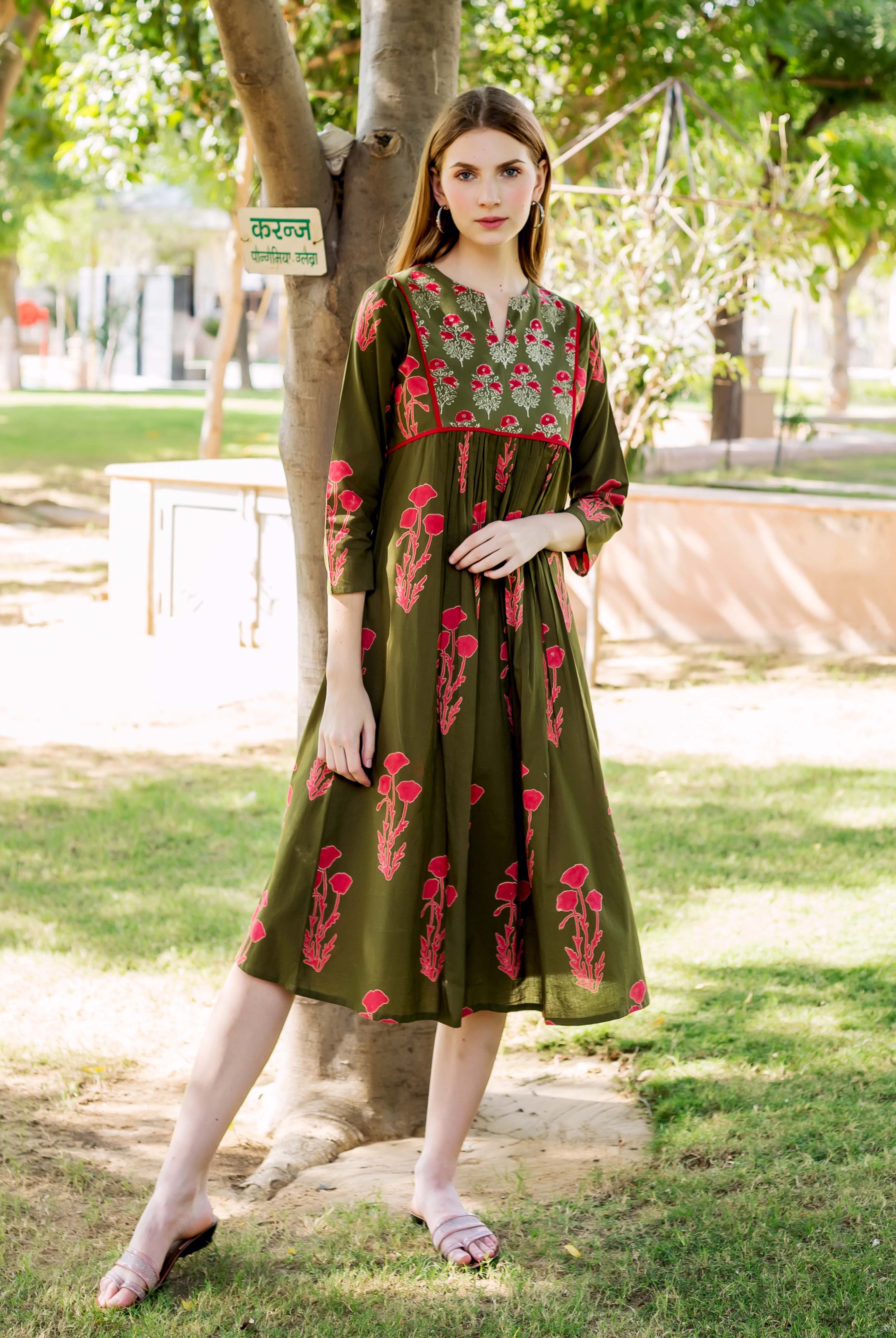 Model wears olive green hand-block printed maternal and nursing dress with red floral print.