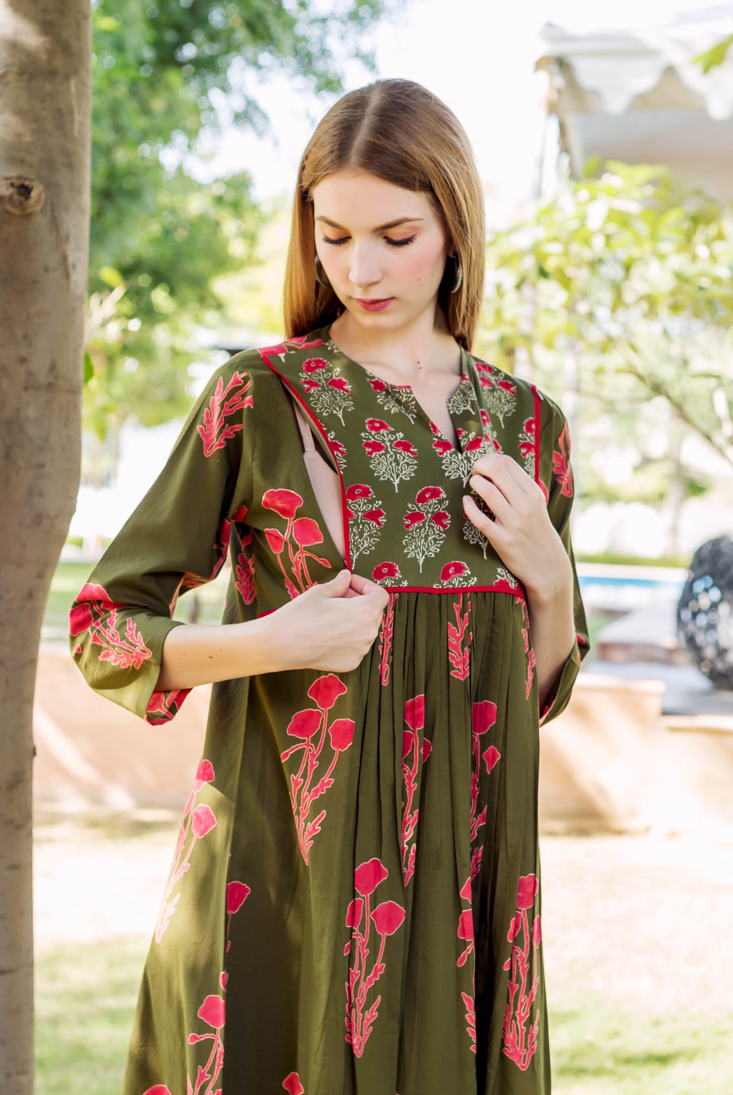 Model in olive green hand-block printed maternal nursing dress with red florals.