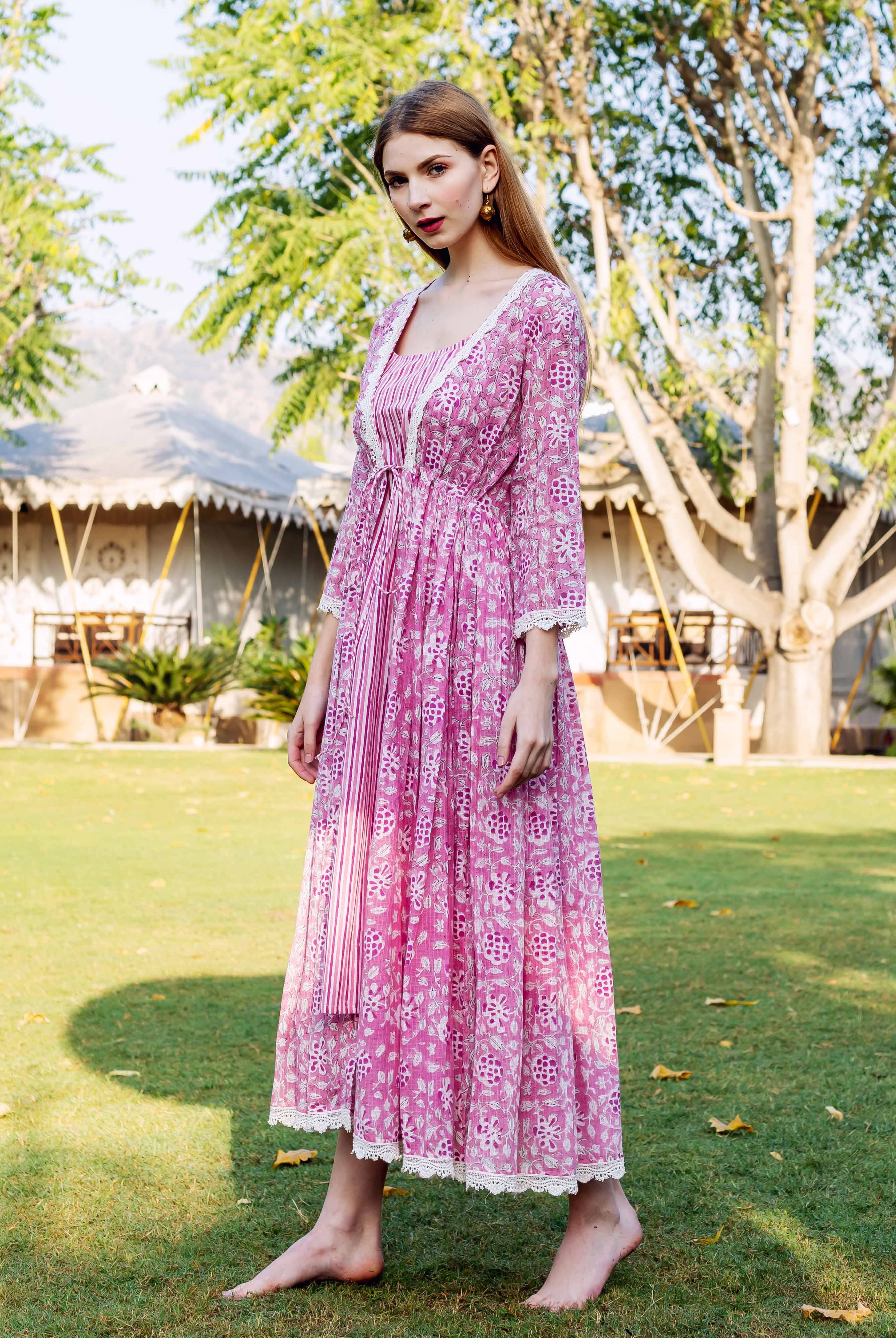 Full-length front view of a model in a pink hand-block-printed ethnic jacket dress with lace trim.