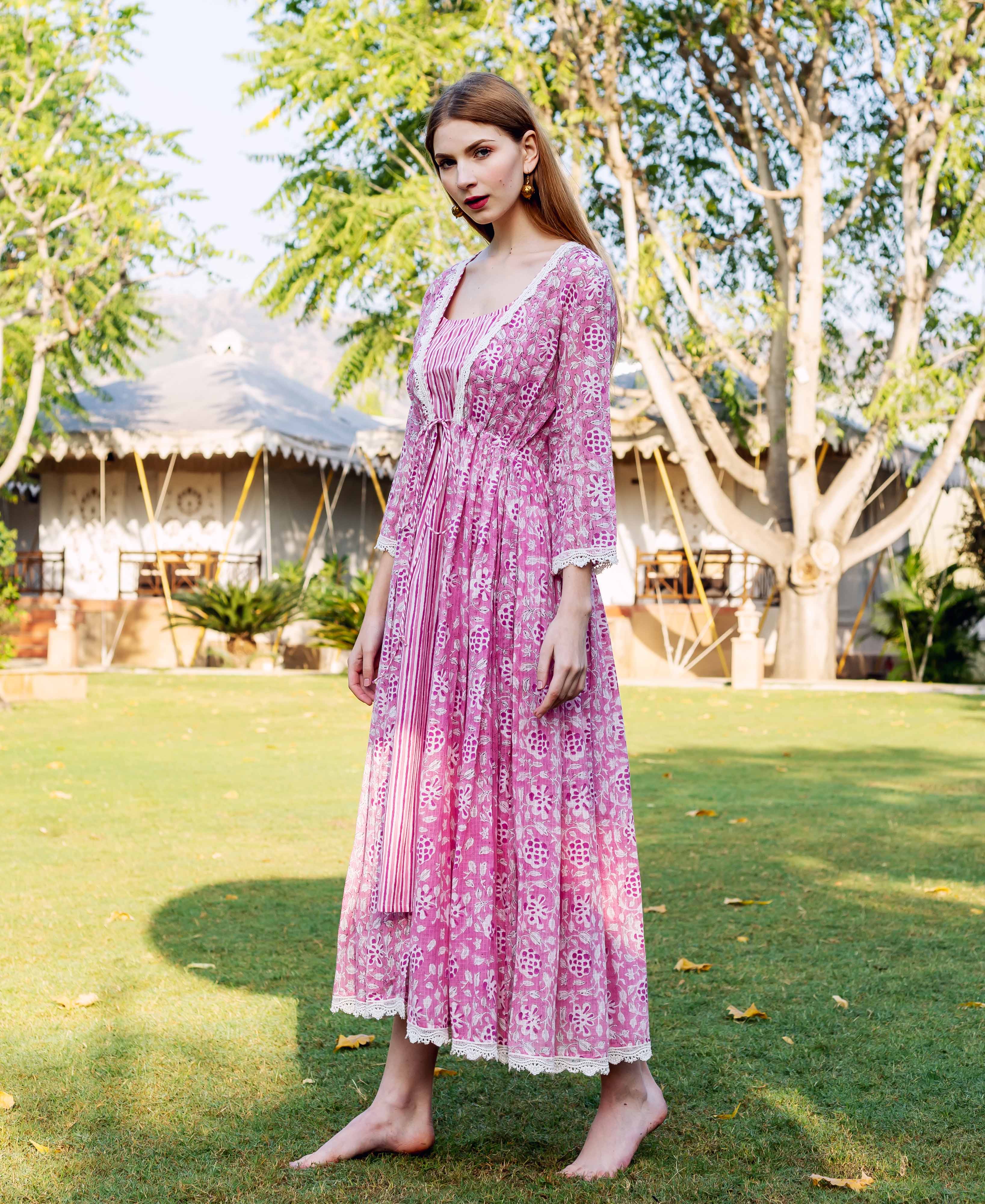 Full-length front view of a model in a pink hand-block-printed ethnic jacket dress with lace trim.
