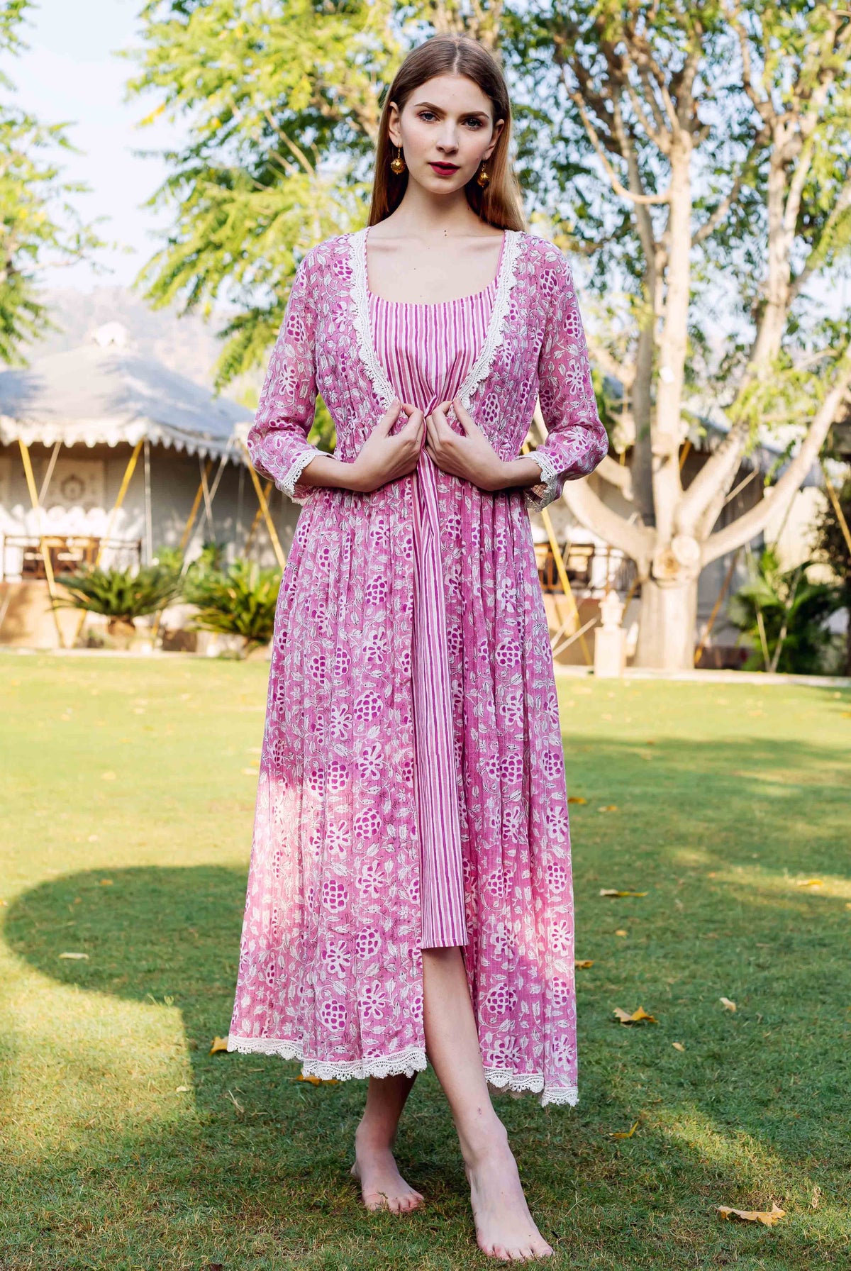 Full-length photo: woman in pink hand-block-printed jacket dress, striped inner, lace trim.