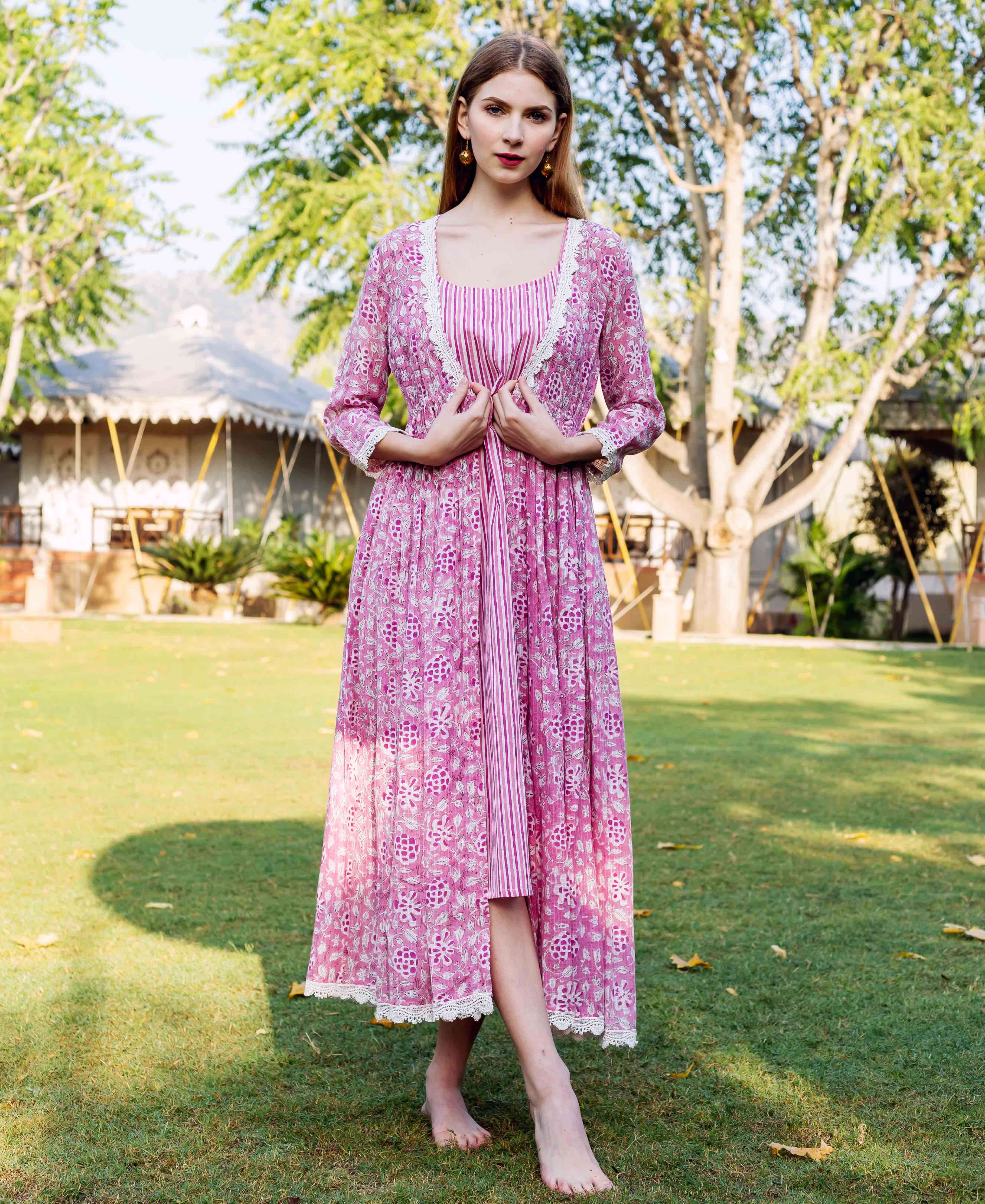 Full-length photo: woman in pink hand-block-printed jacket dress, striped inner, lace trim.