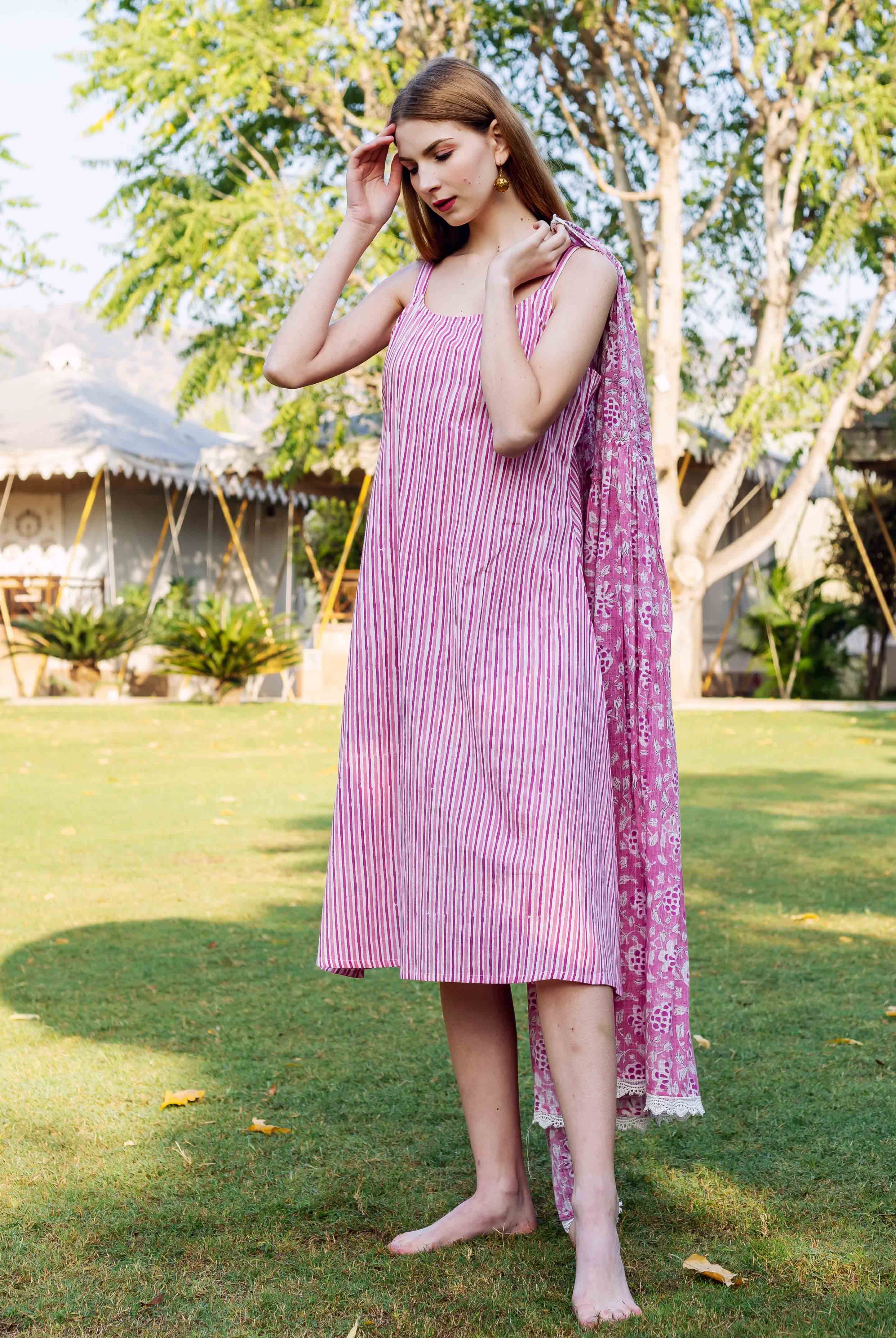 Model in a pink hand-block printed striped dress with a floral printed matching dupatta.