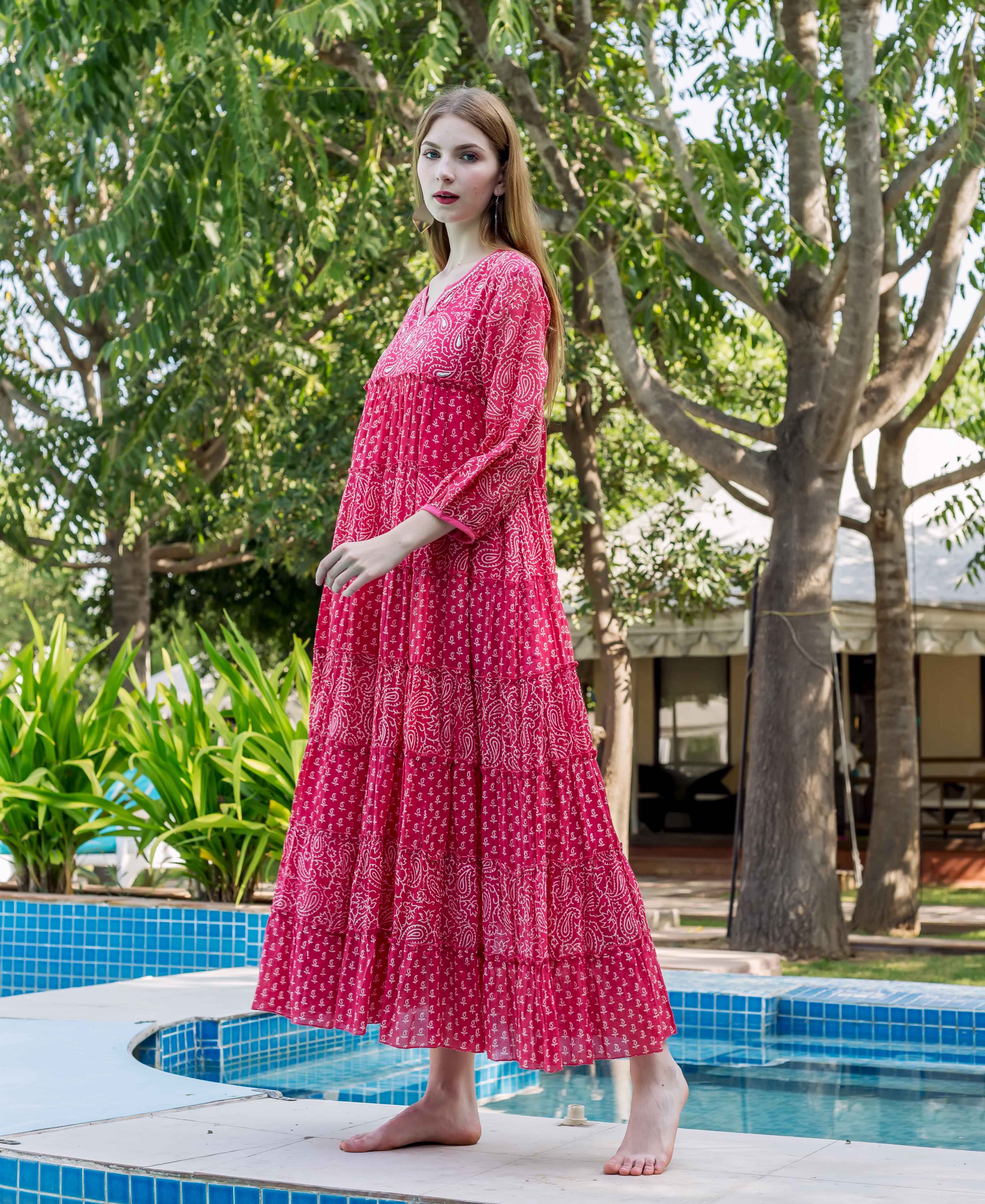 Model wearing vibrant pink tiered dress with white paisley hand-block print.