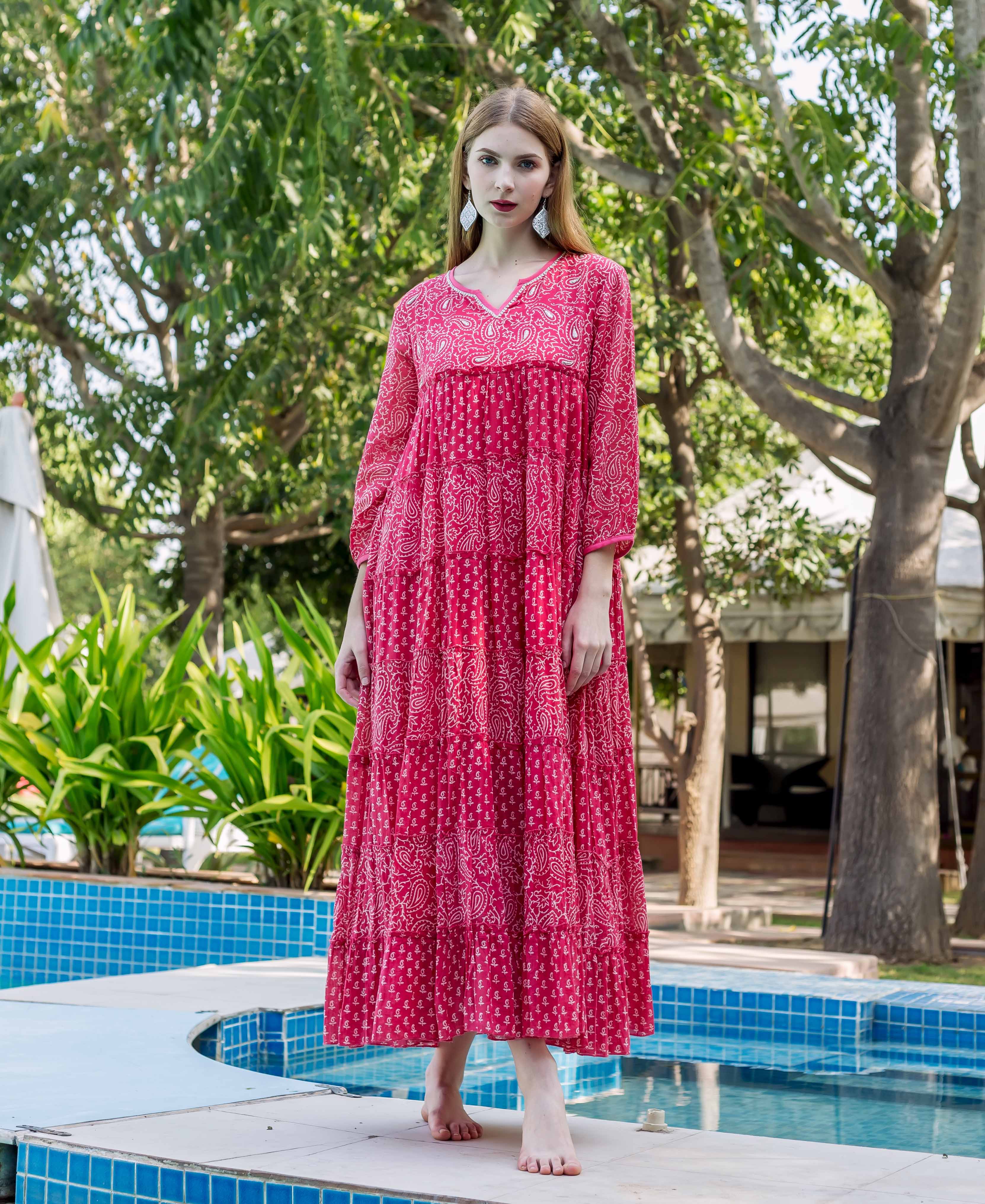 Model in a fuchsia tiered dress with embroidered V-neck and white ethnic hand-block prints.
