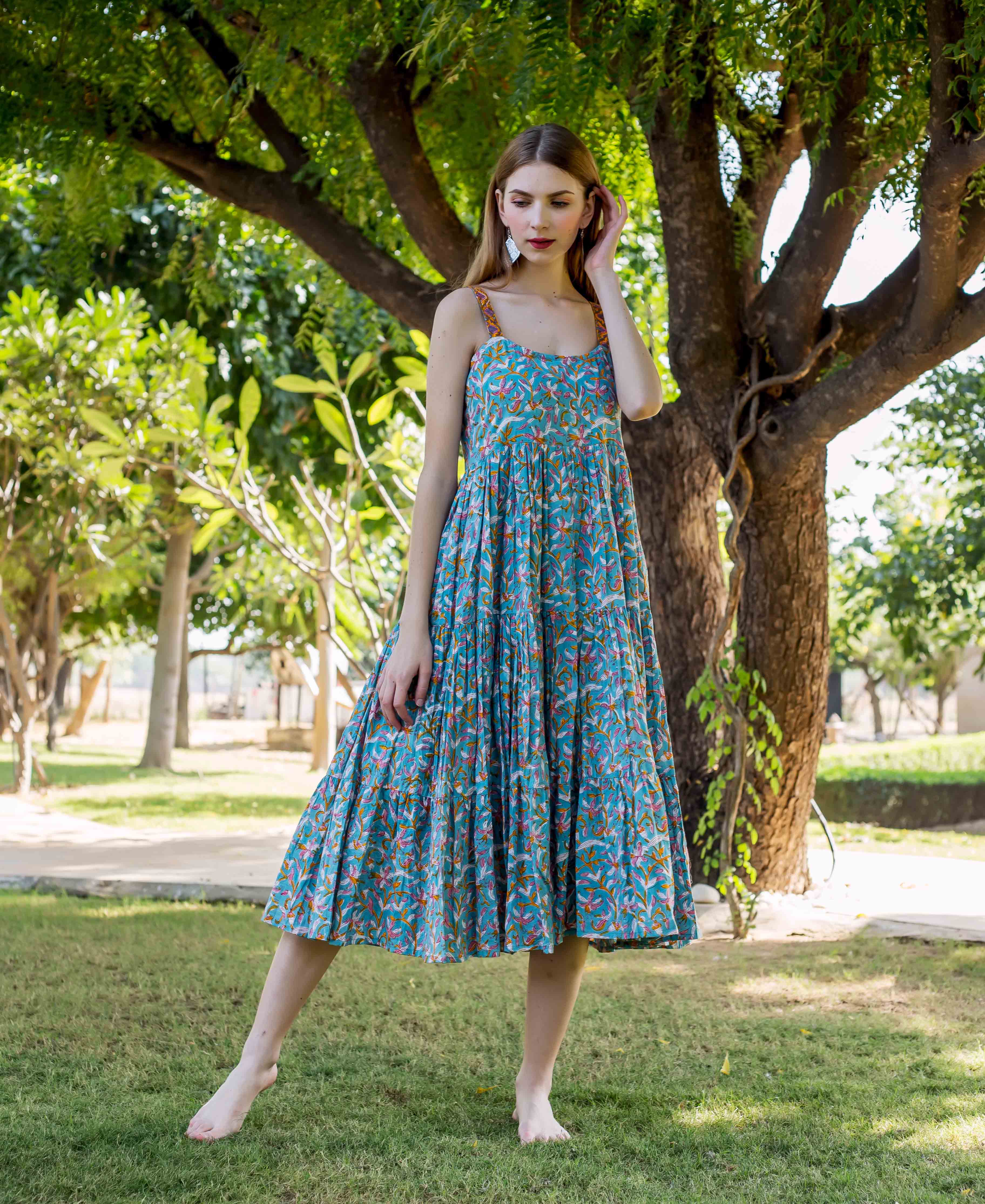 Model in front view wearing a teal hand-block printed tiered floral midi dress.