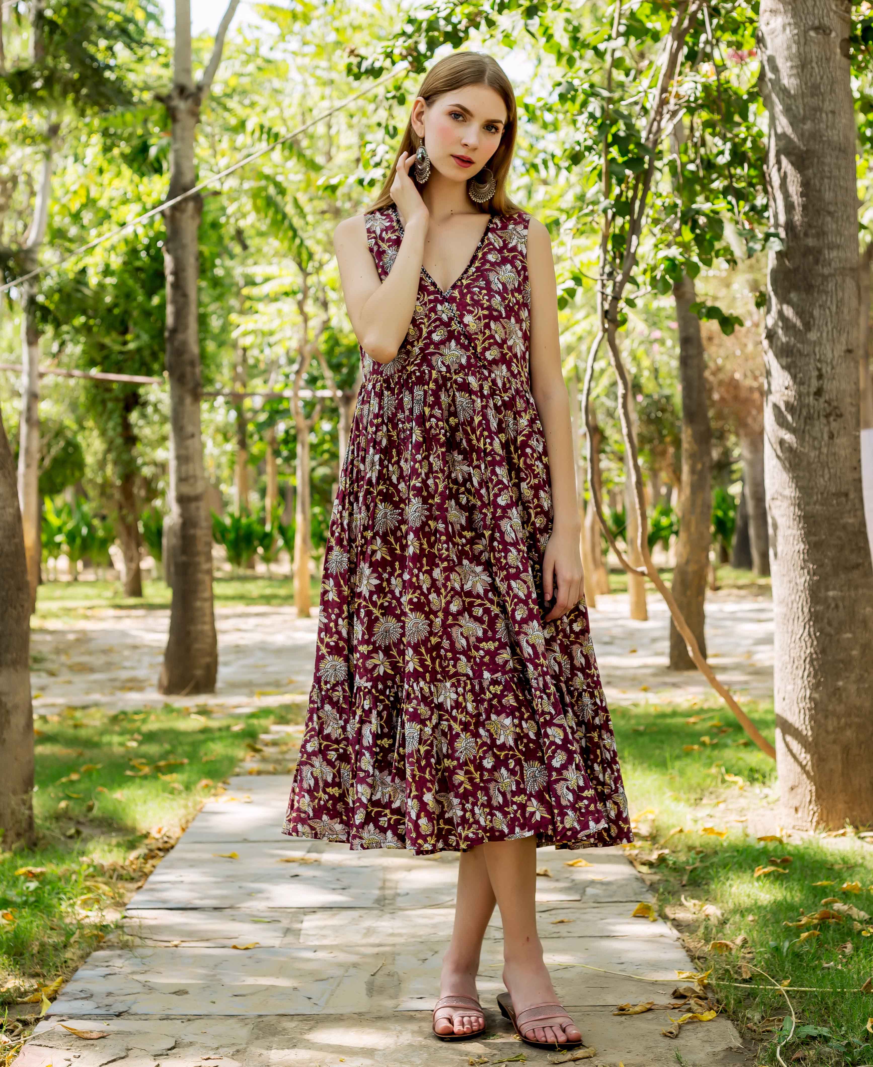 Full front view of model in maroon hand-block printed tiered dress with floral motifs.