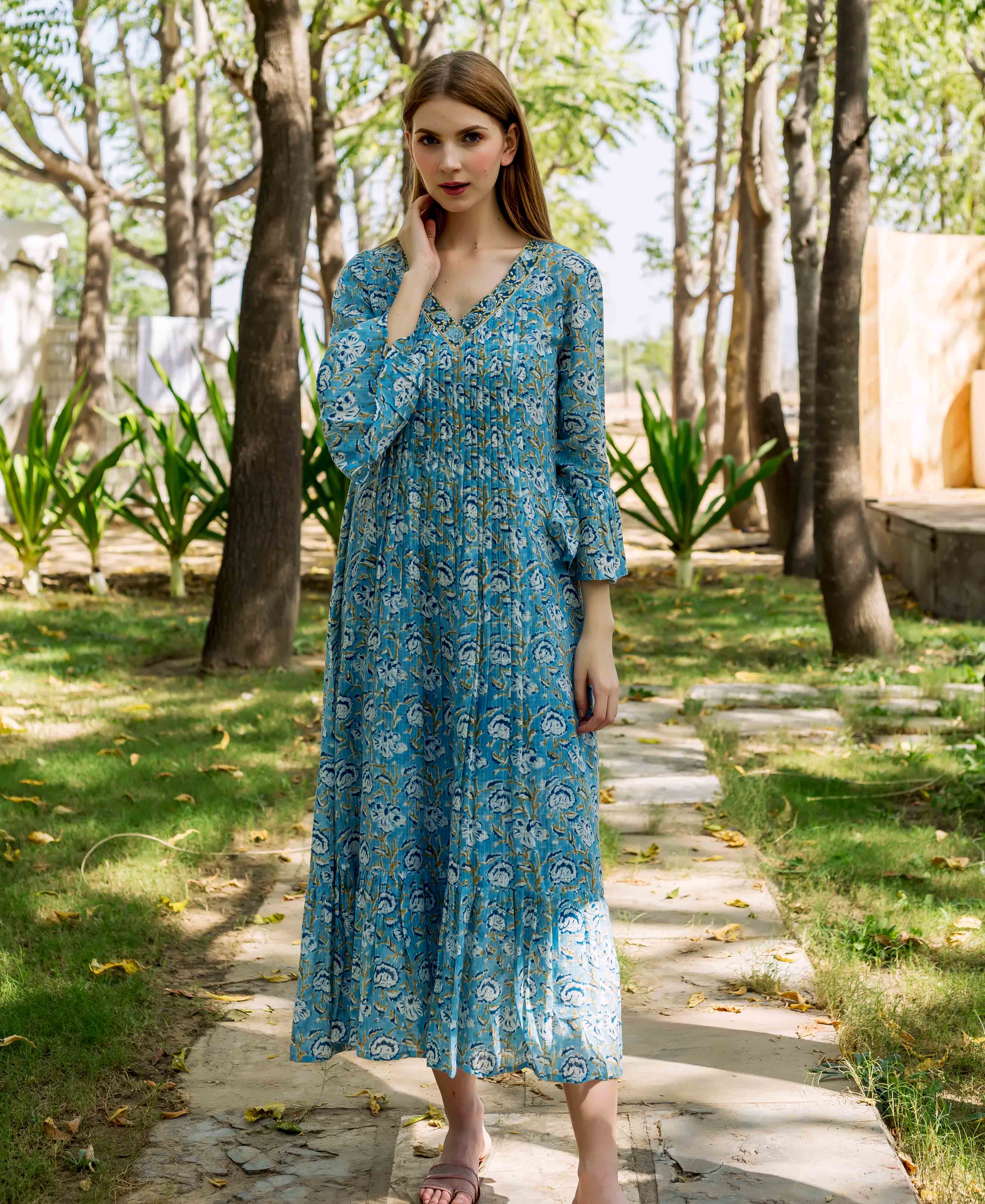 Front view model in blue hand-block-printed floral maxi dress with pleated bodice.