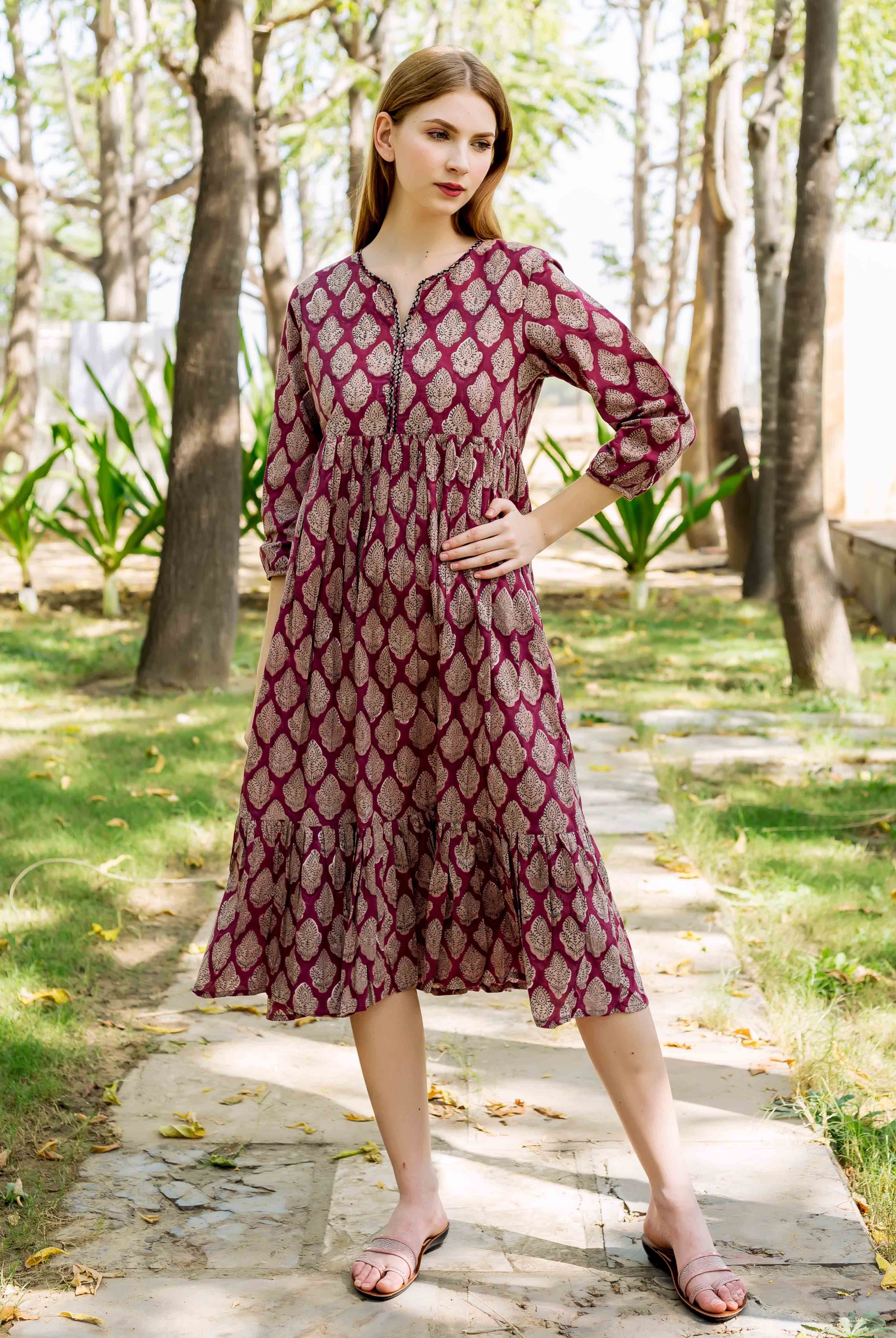 Full-length shot of a model in a maroon hand-block-printed ethnic dress with a leaf pattern.