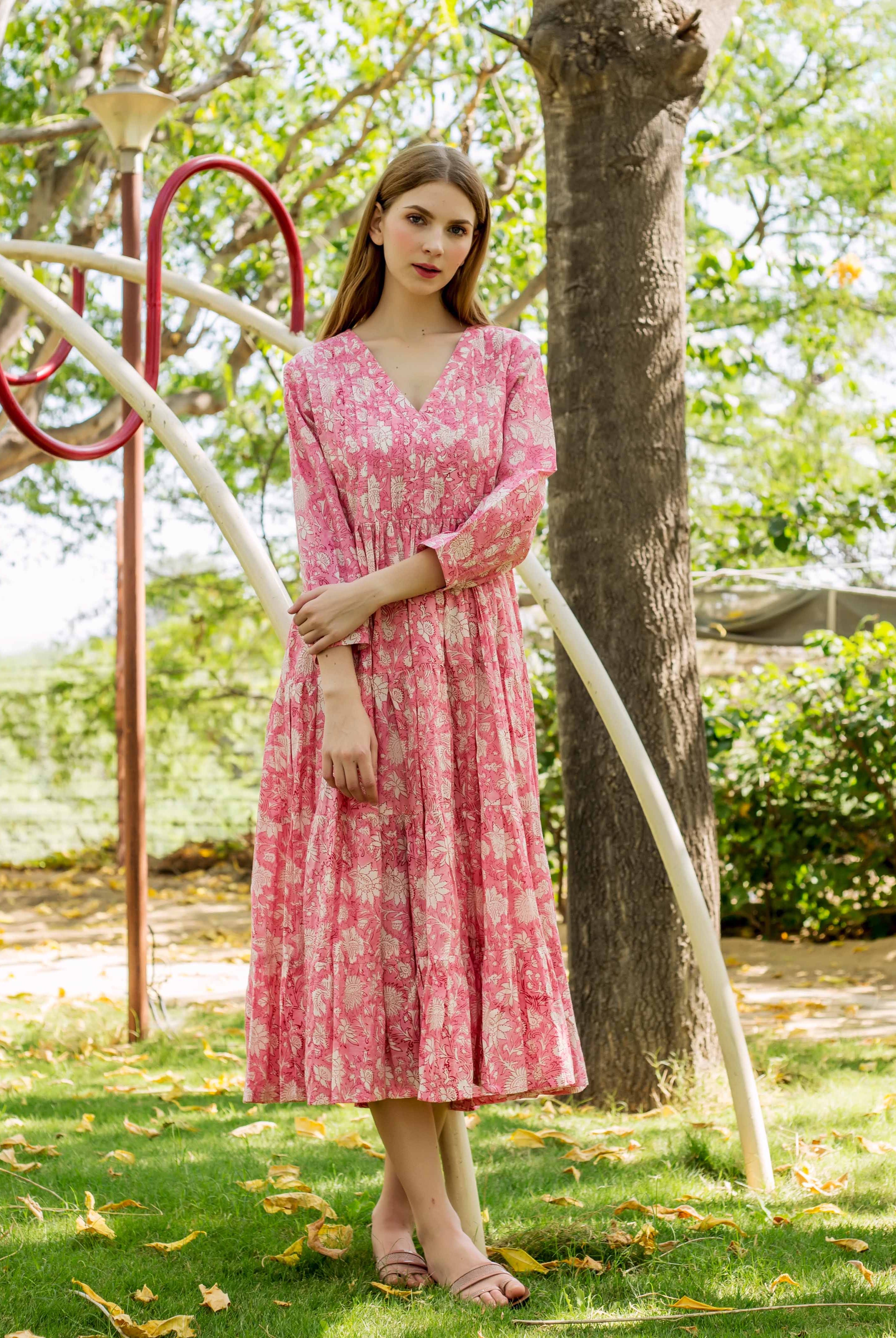 Model wears a pink V-neck hand-block-printed ethnic dress with white floral design.