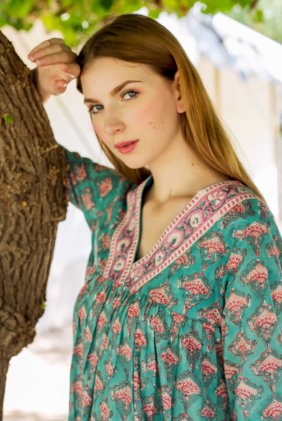 Model wears Eliza Green Tiered Dress, teal with rose hand-block print, V-neck.
