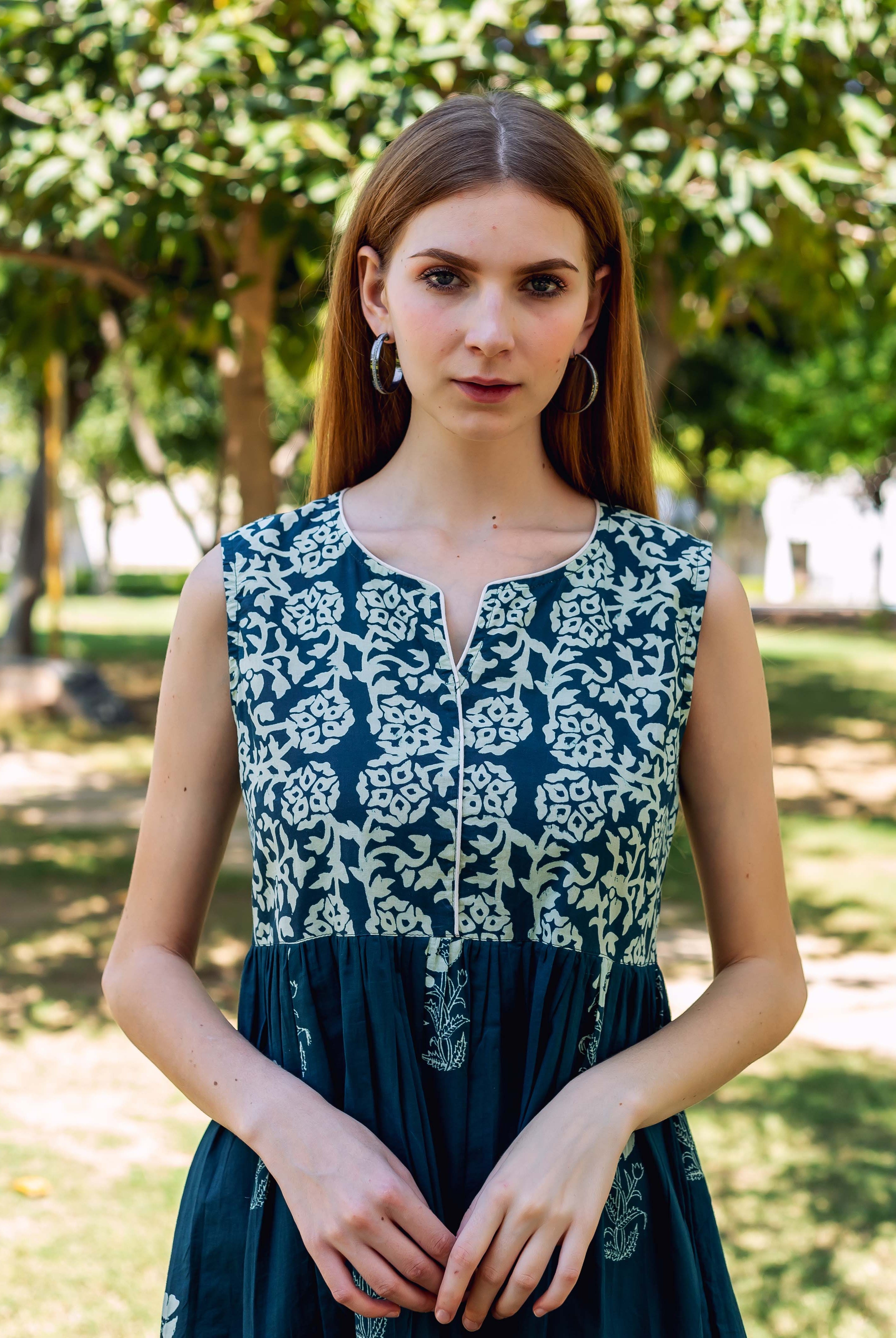 Front view model in sleeveless teal green dress with floral block-printed yoke.