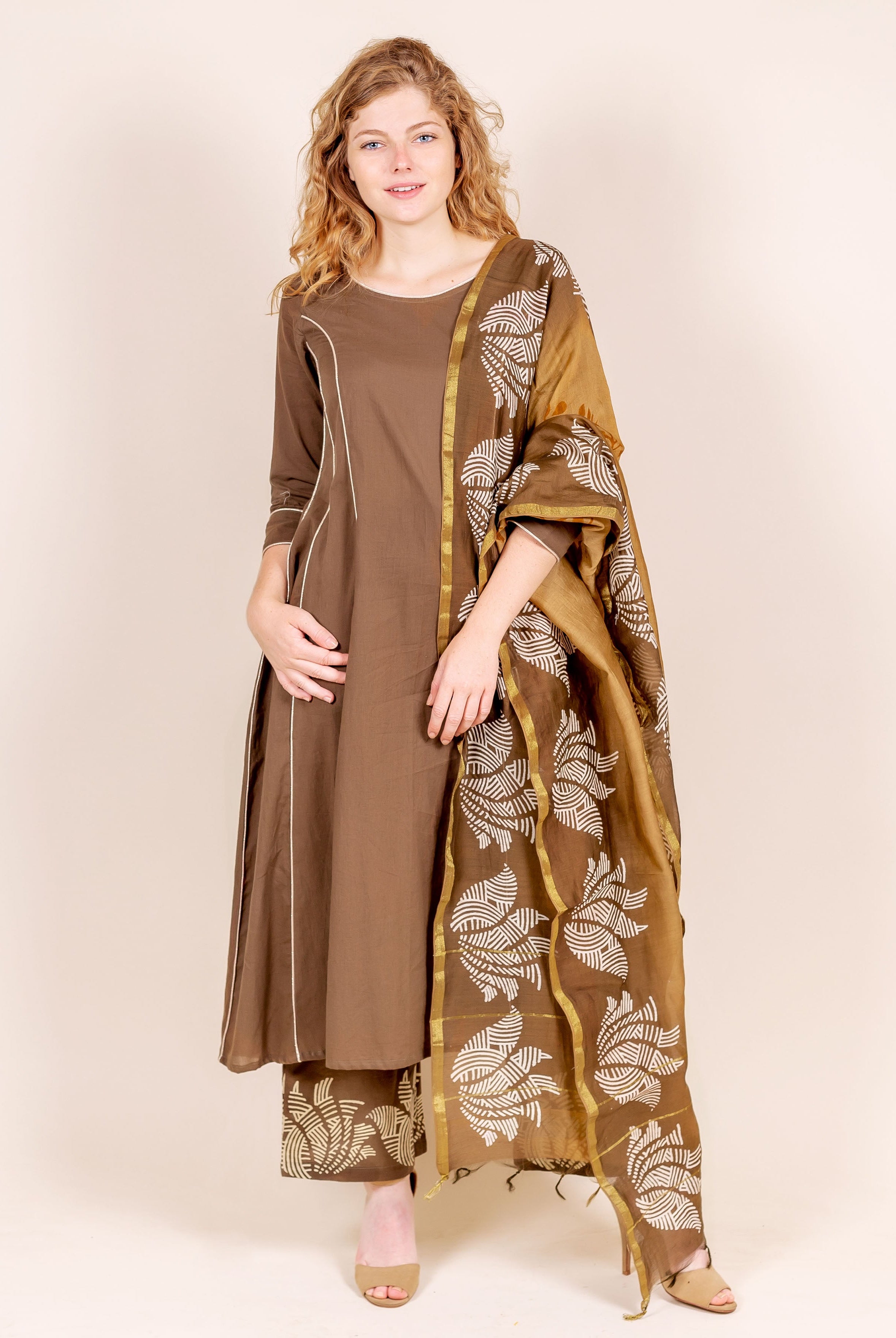Model in brown kurta with white trim, beige hand-block printed pants and matching dupatta.