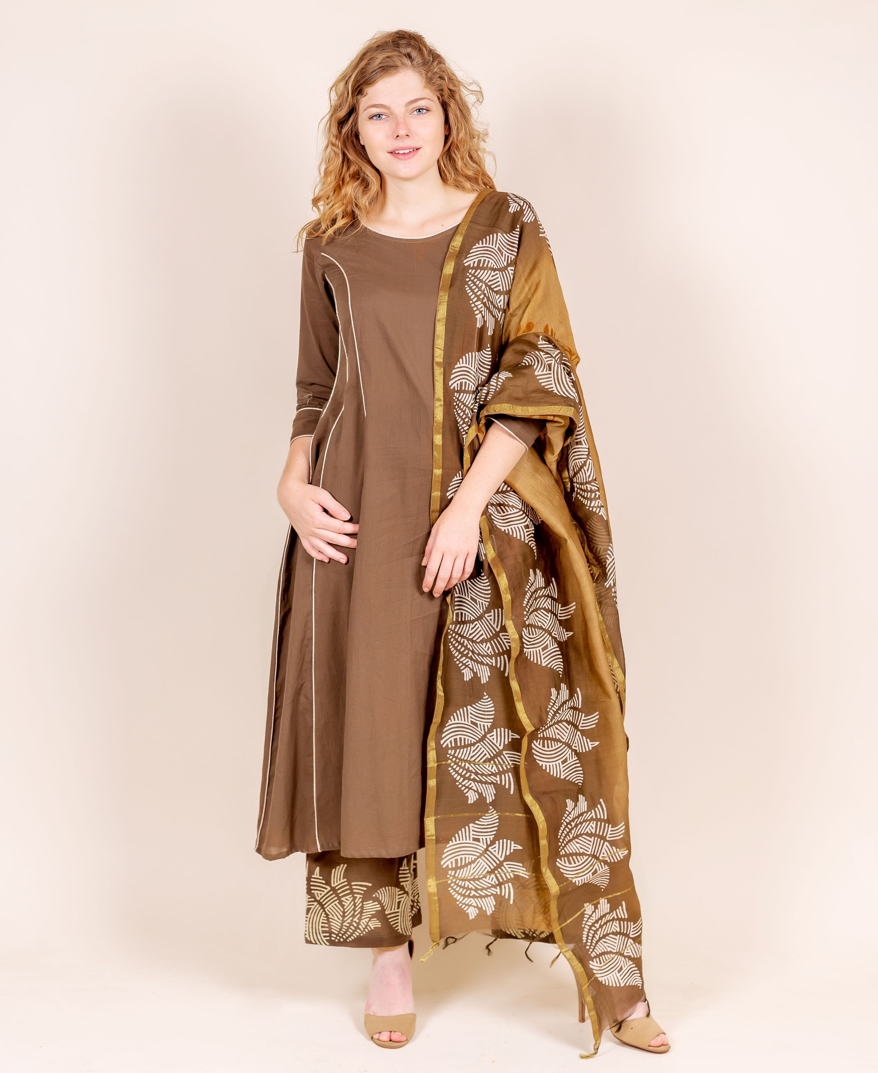 Model in brown kurta with white trim, beige hand-block printed pants and matching dupatta.