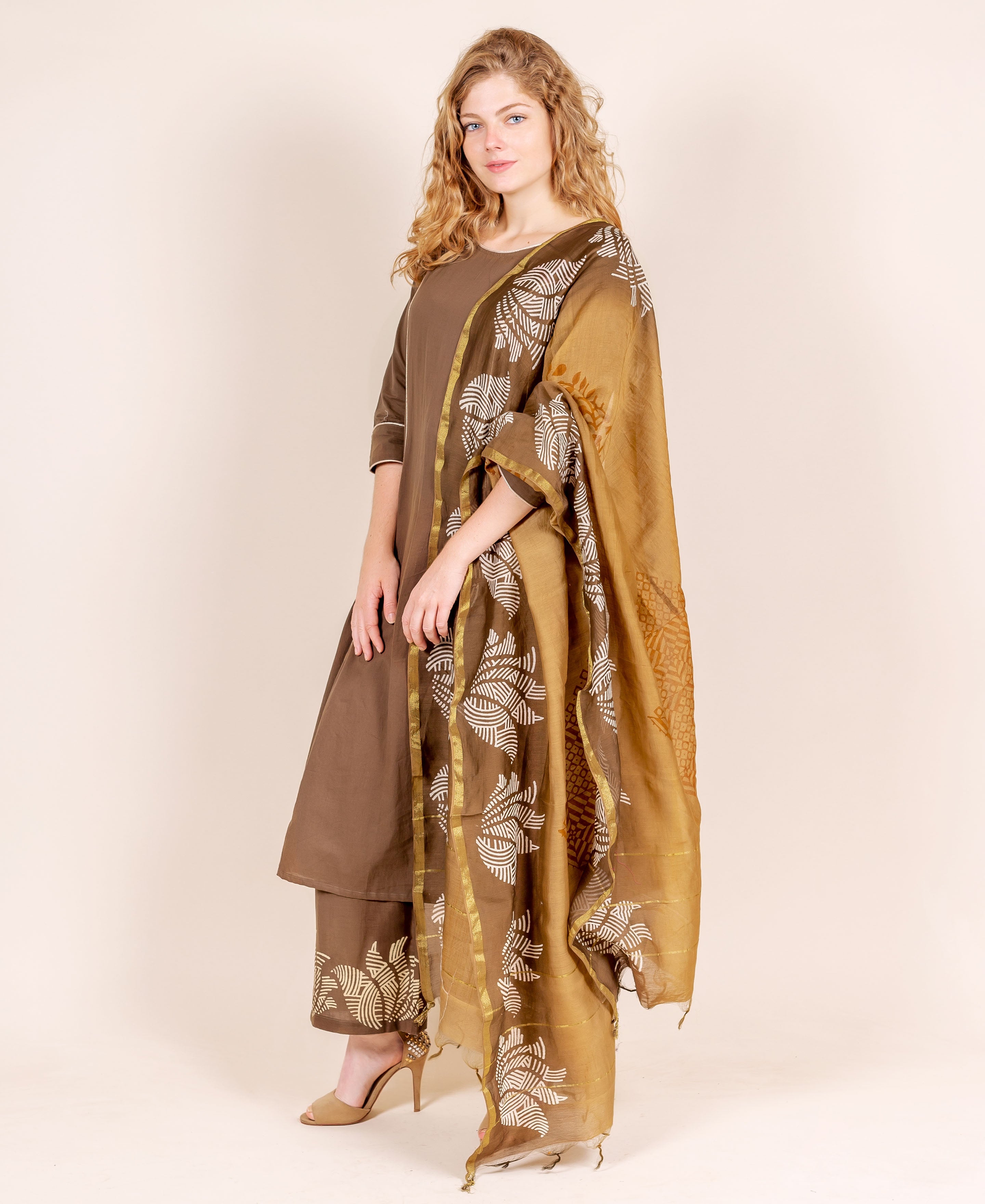 On a model, an angled brown kurta and pants with white hand-block printed beige dupatta.