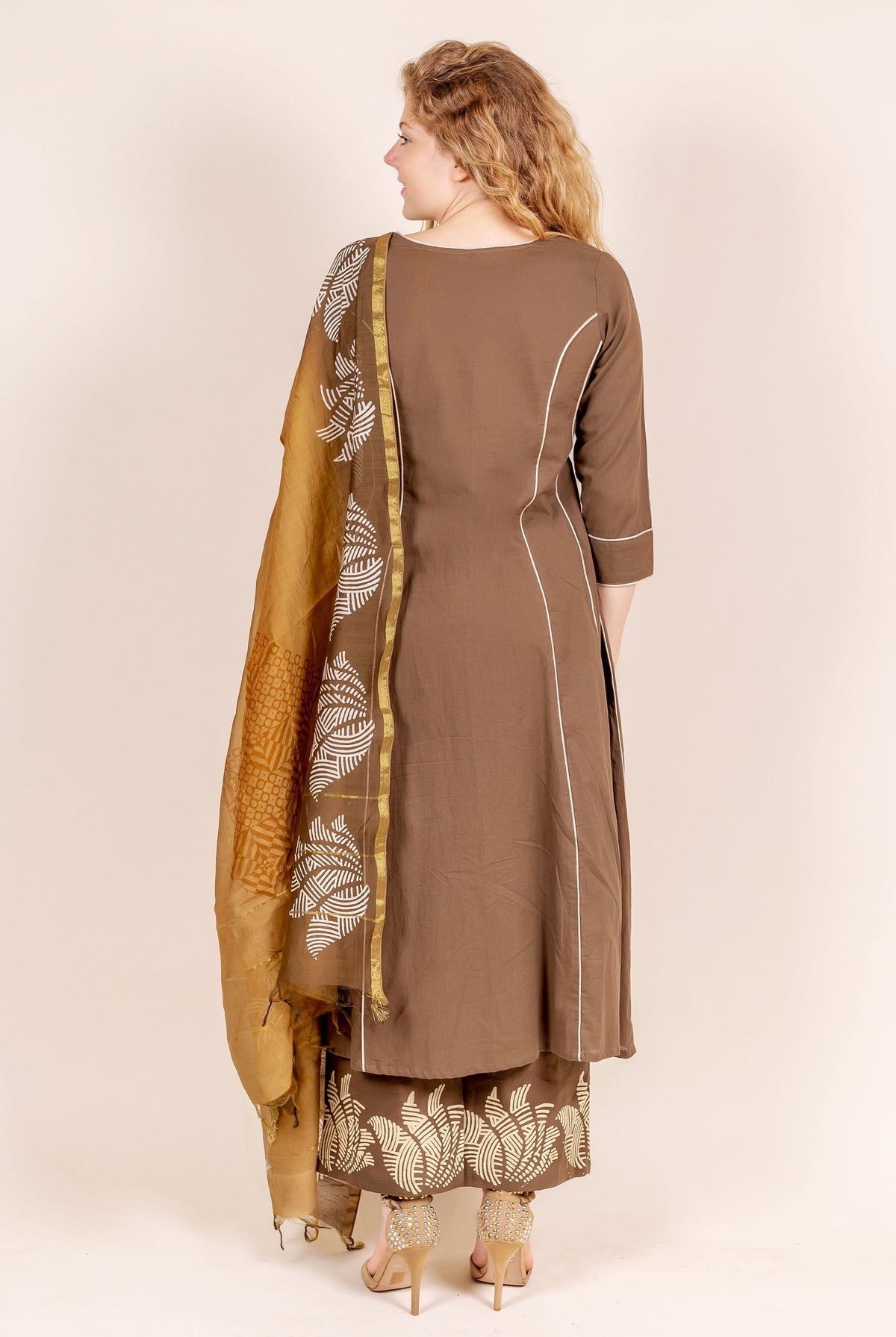 Back view of woman in brown kurta set with beige hand-block printed dupatta and palazzo.