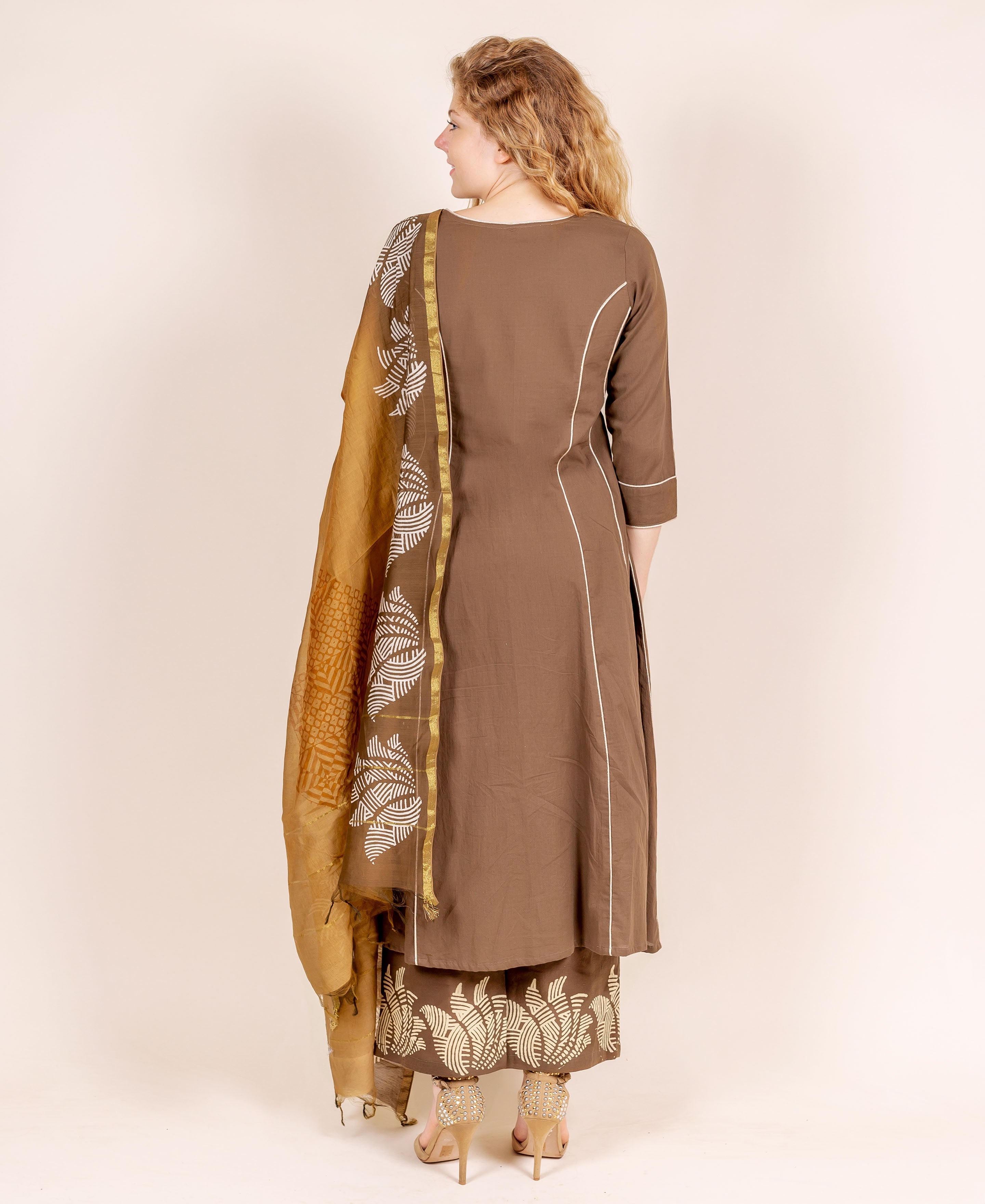 Back view of woman in brown kurta set with beige hand-block printed dupatta and palazzo.