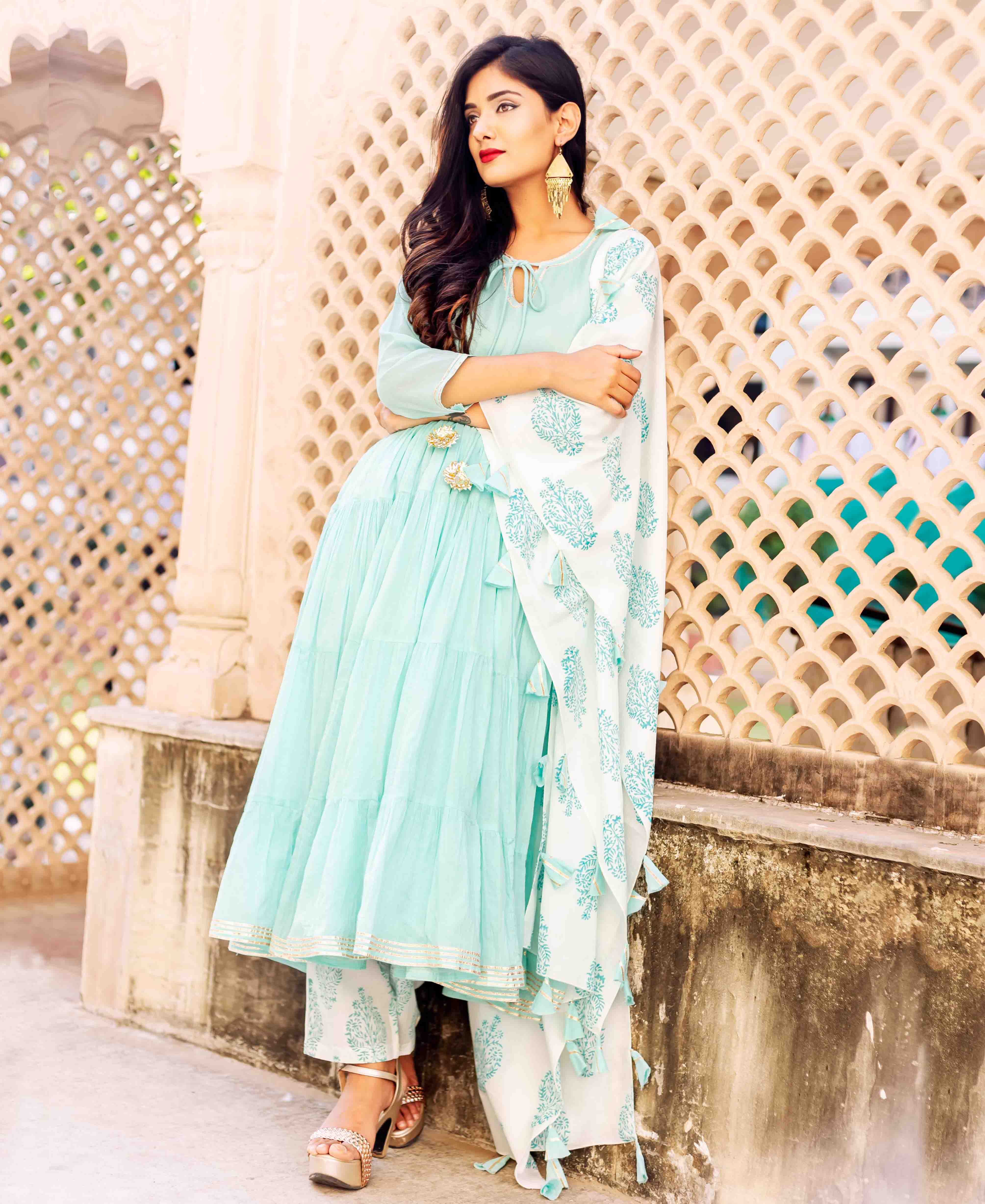 Model wears light blue tiered kurta, white block-printed palazzo, and matching dupatta with tassels.