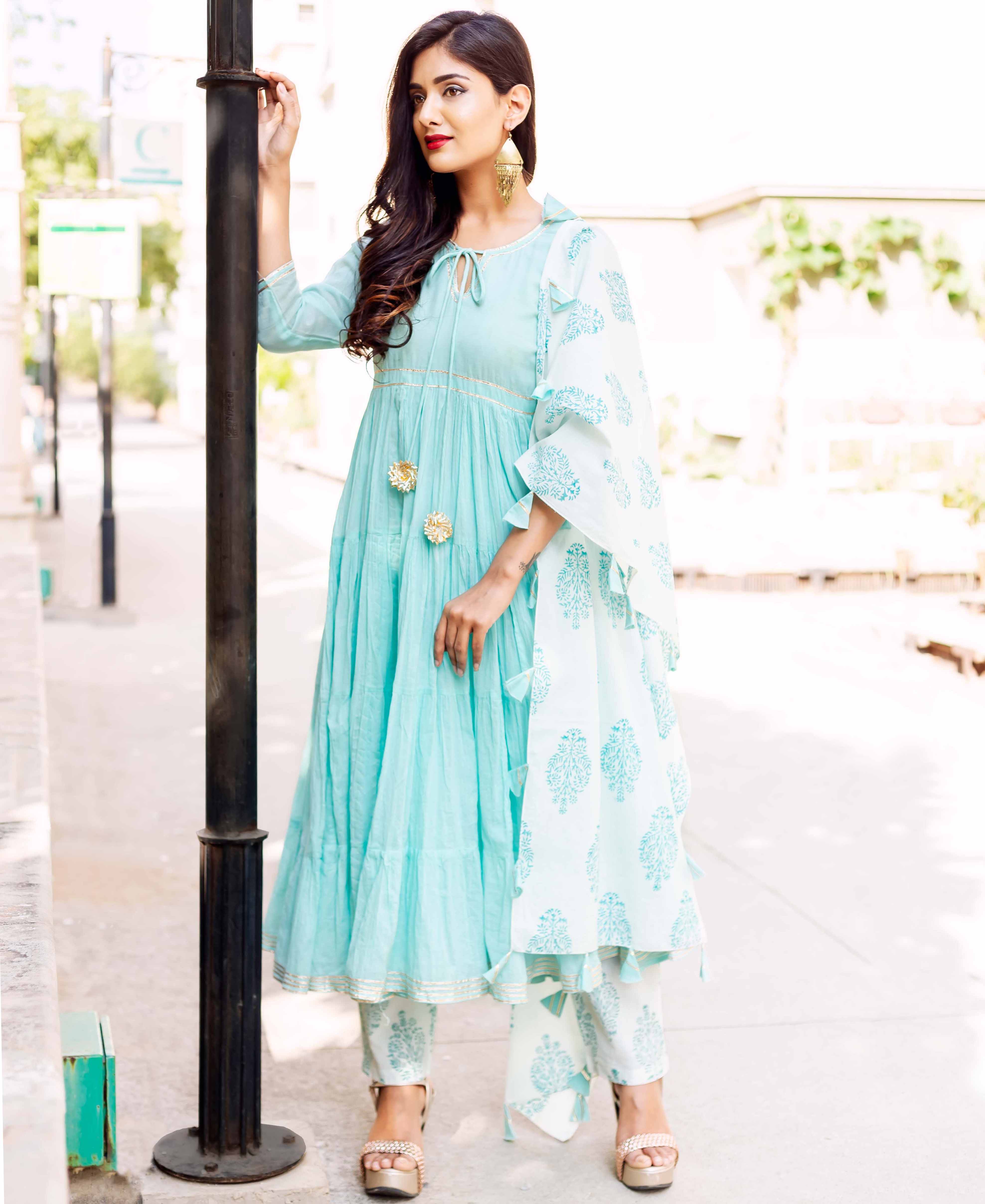 Model in a full-length aqua tiered kurta set with white hand-block printed dupatta and bottoms.
