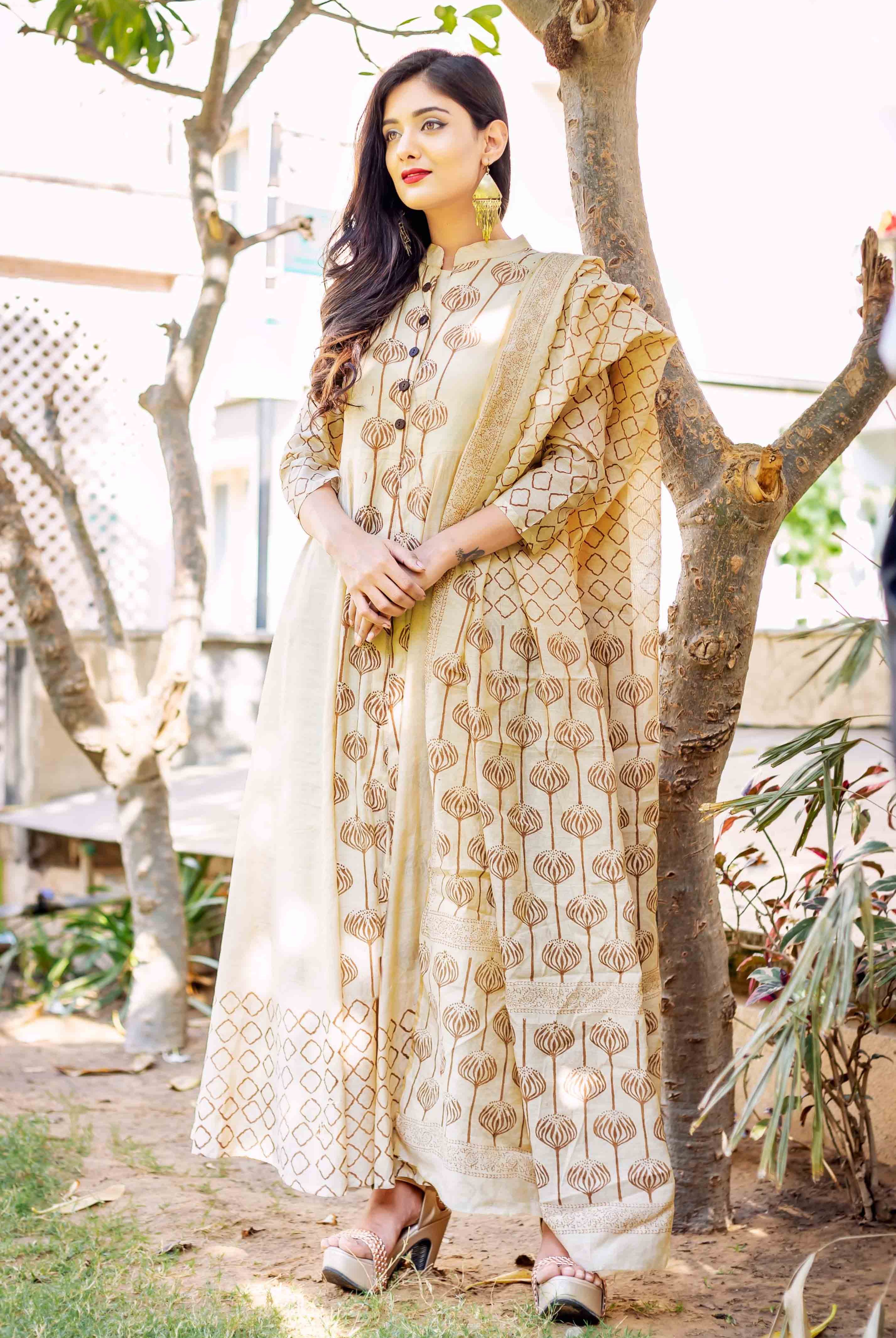 Beige and brown hand-block-printed ethnic dress with floral pattern on model outdoors.