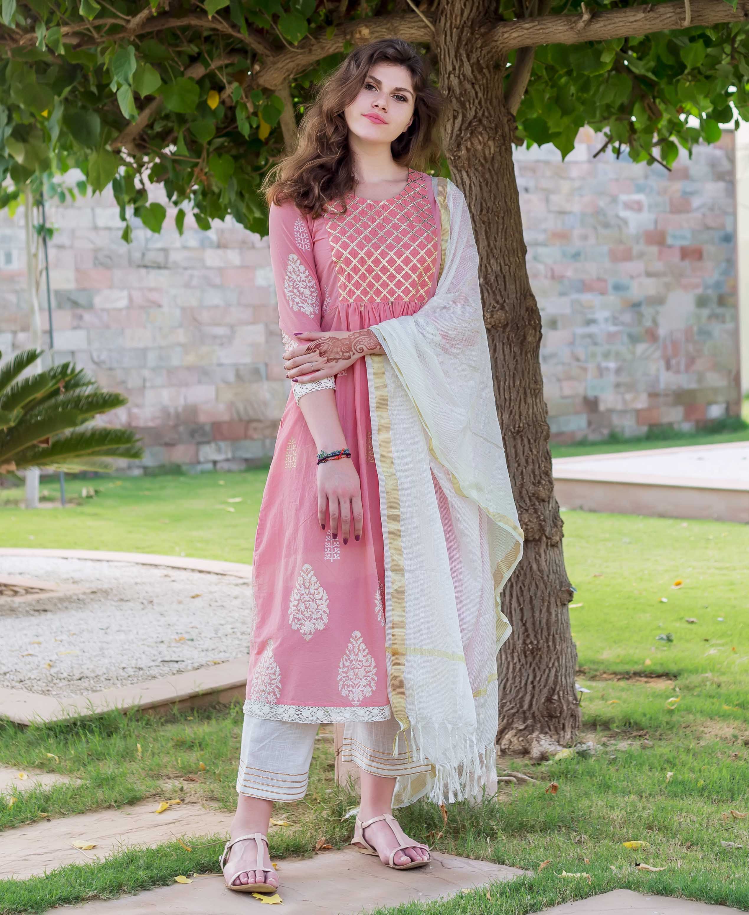 Full-body model wears a pink A-line kurta with gold and white hand-block print.