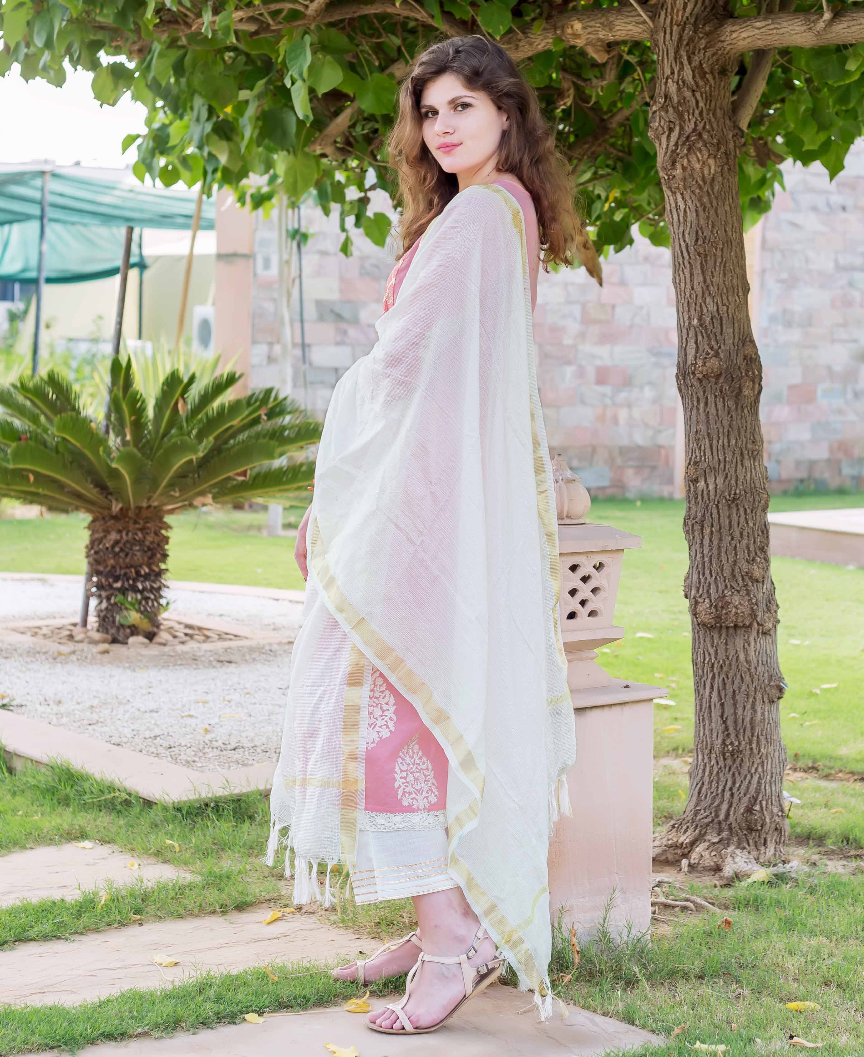 Model in pink hand-block printed kurta with white palazzo and sheer dupatta.