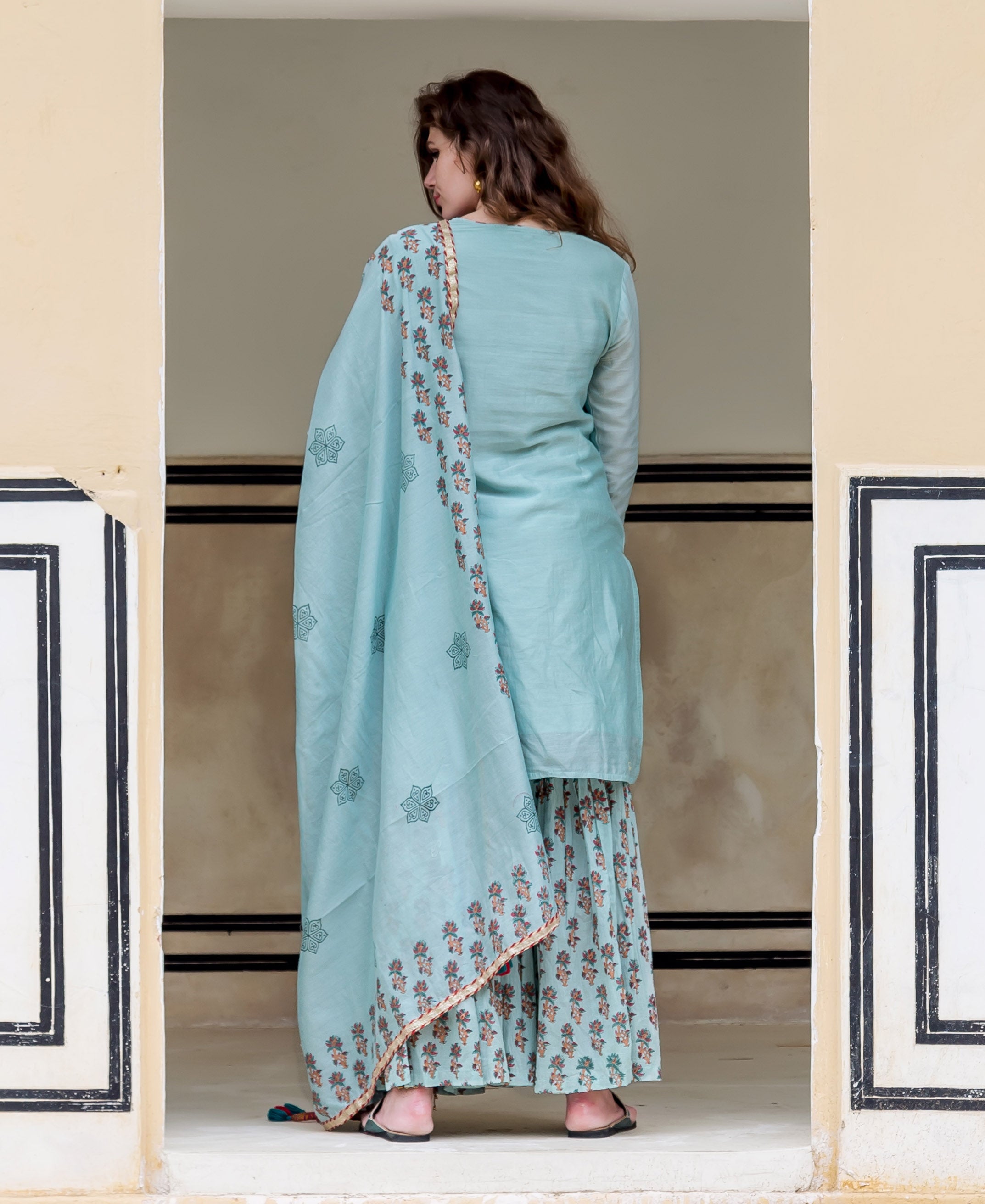 A model wearing a light blue kurta with a floral pattern.