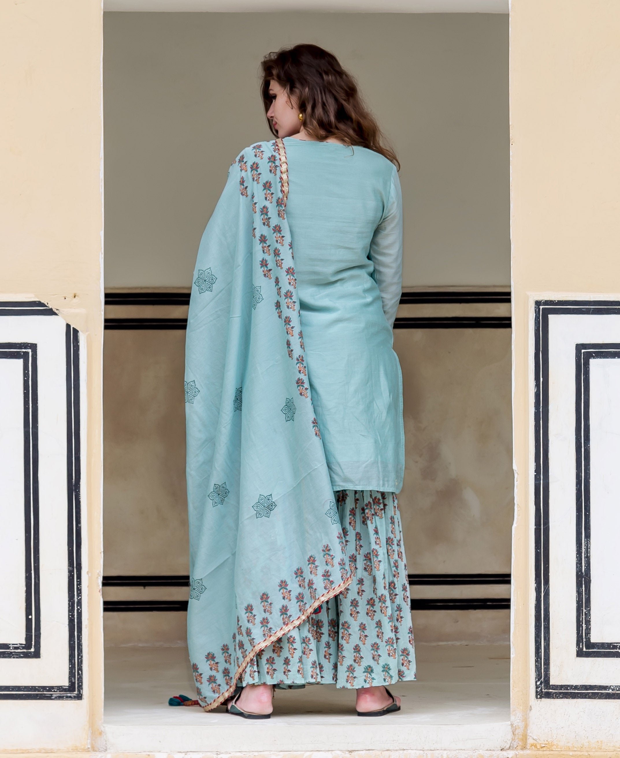 A model wearing a light blue kurta with a floral pattern.