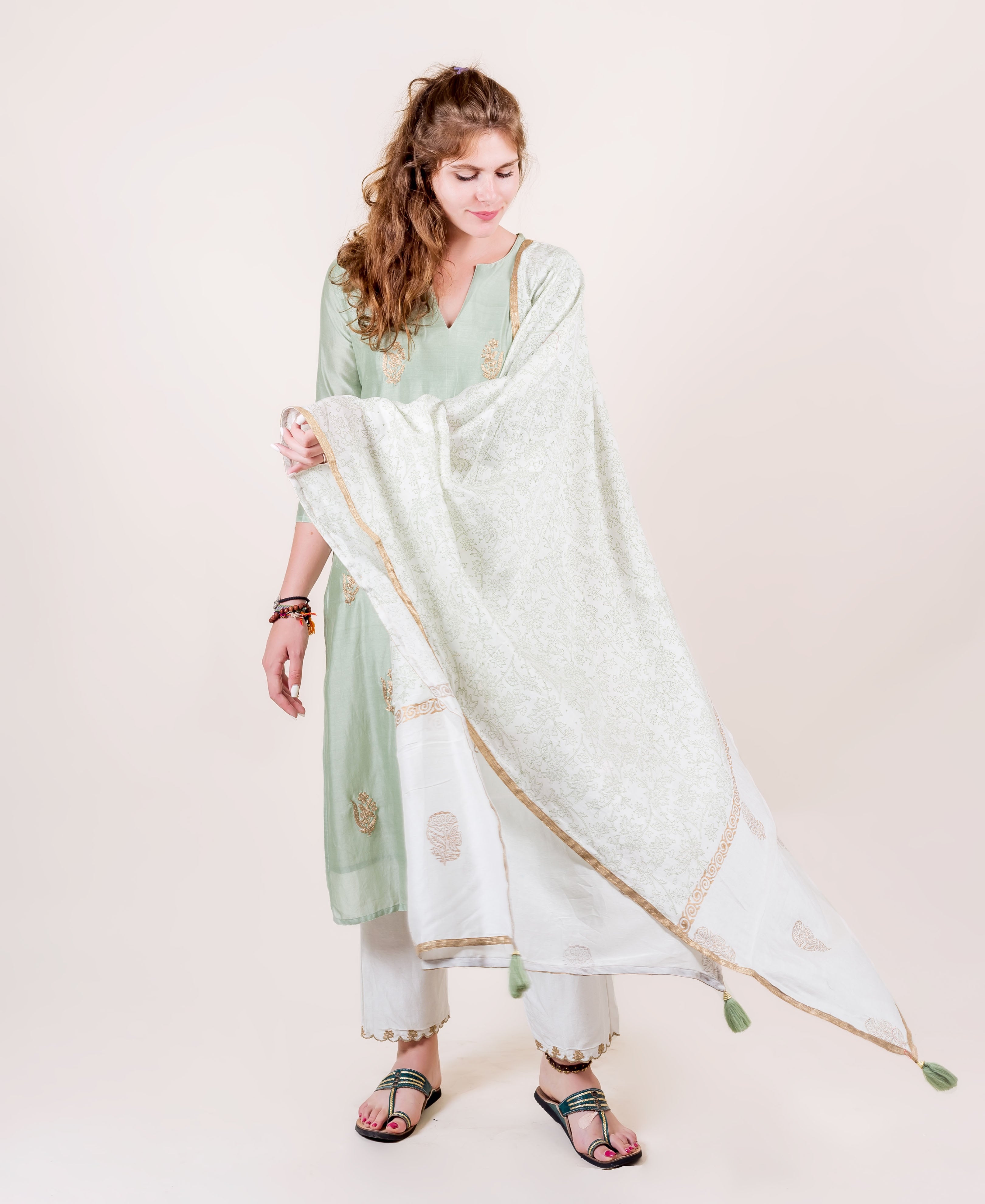 Model in mint kurta, ivory bottoms, and hand-block printed dupatta with gold trim.