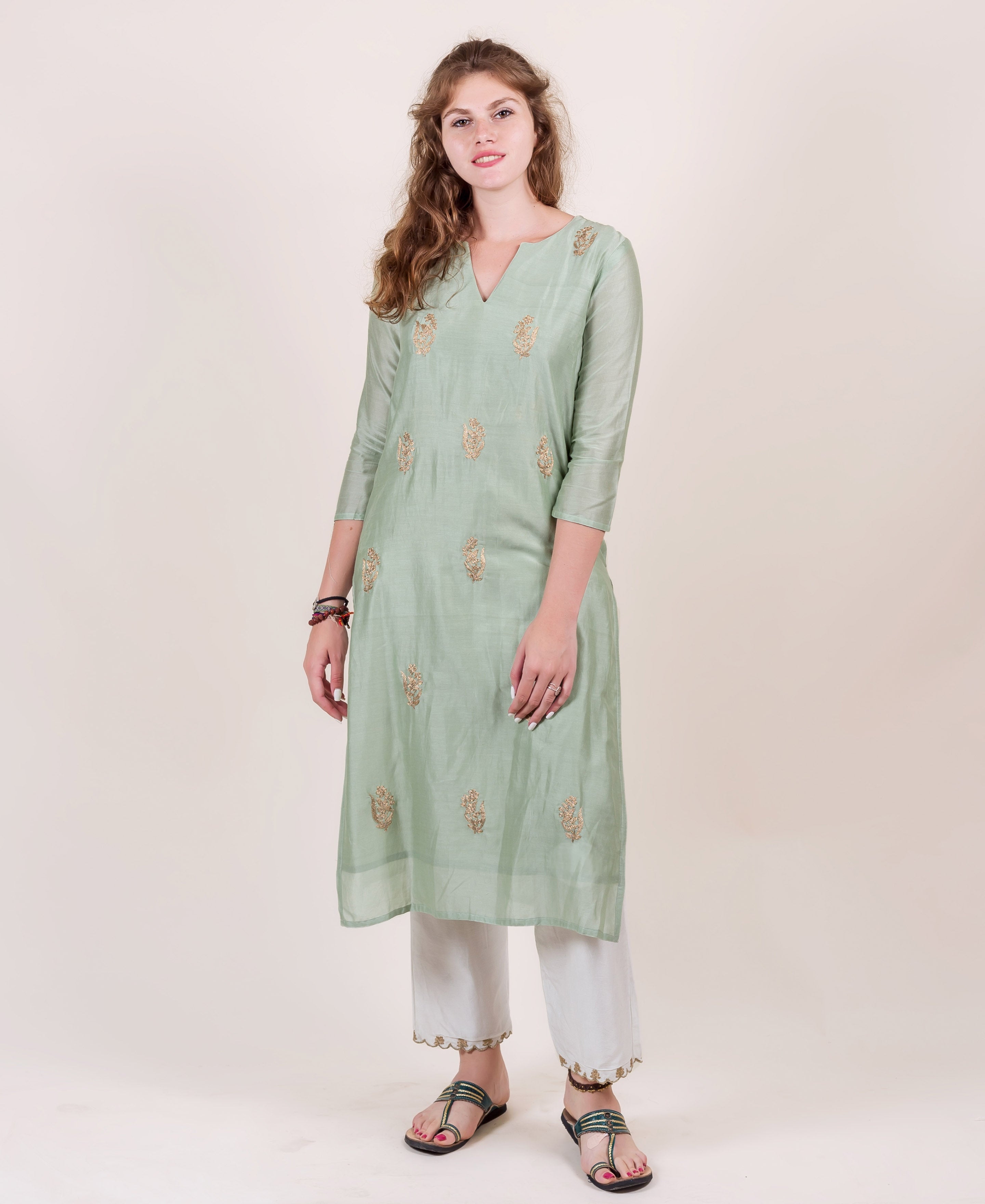 Mint green kurta with gold floral motifs, V-neck and 3/4 sleeves on a model.