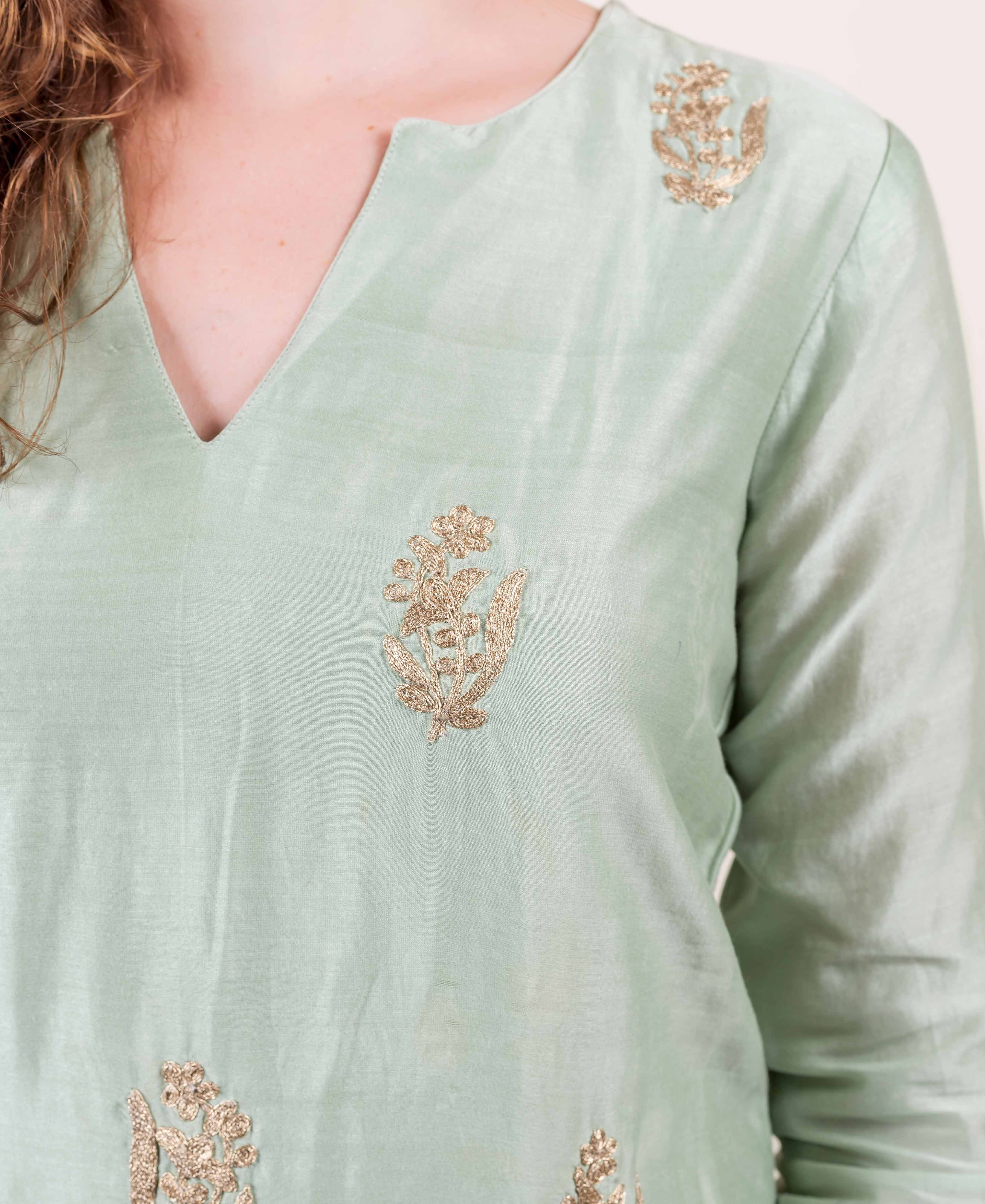 Mint green tunic with gold floral embroidery, V-neck and long sleeve visible.